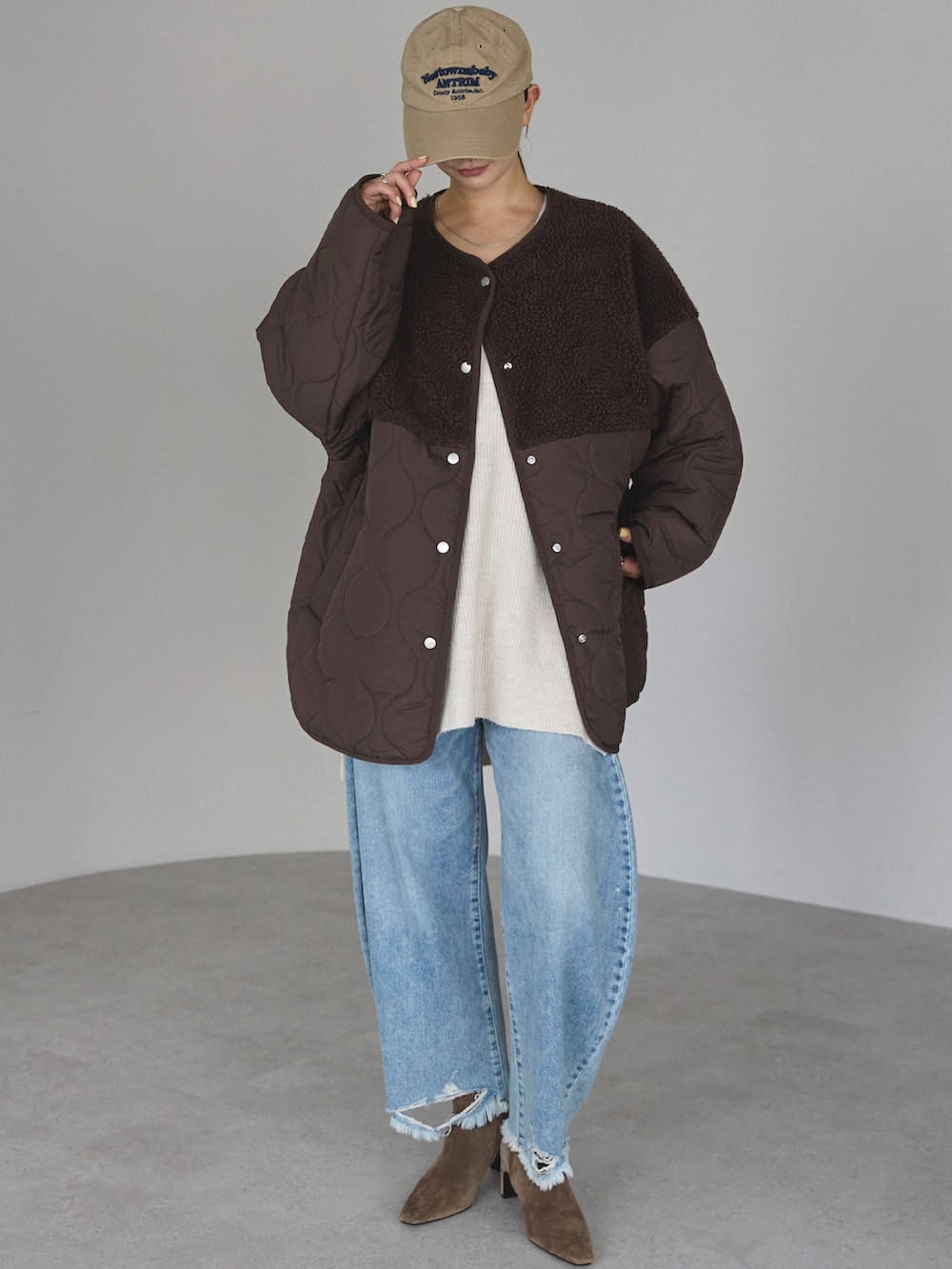 ブラウン系のノーカラージャケットを着用したレディースの冬コーディネートの2枚目の写真