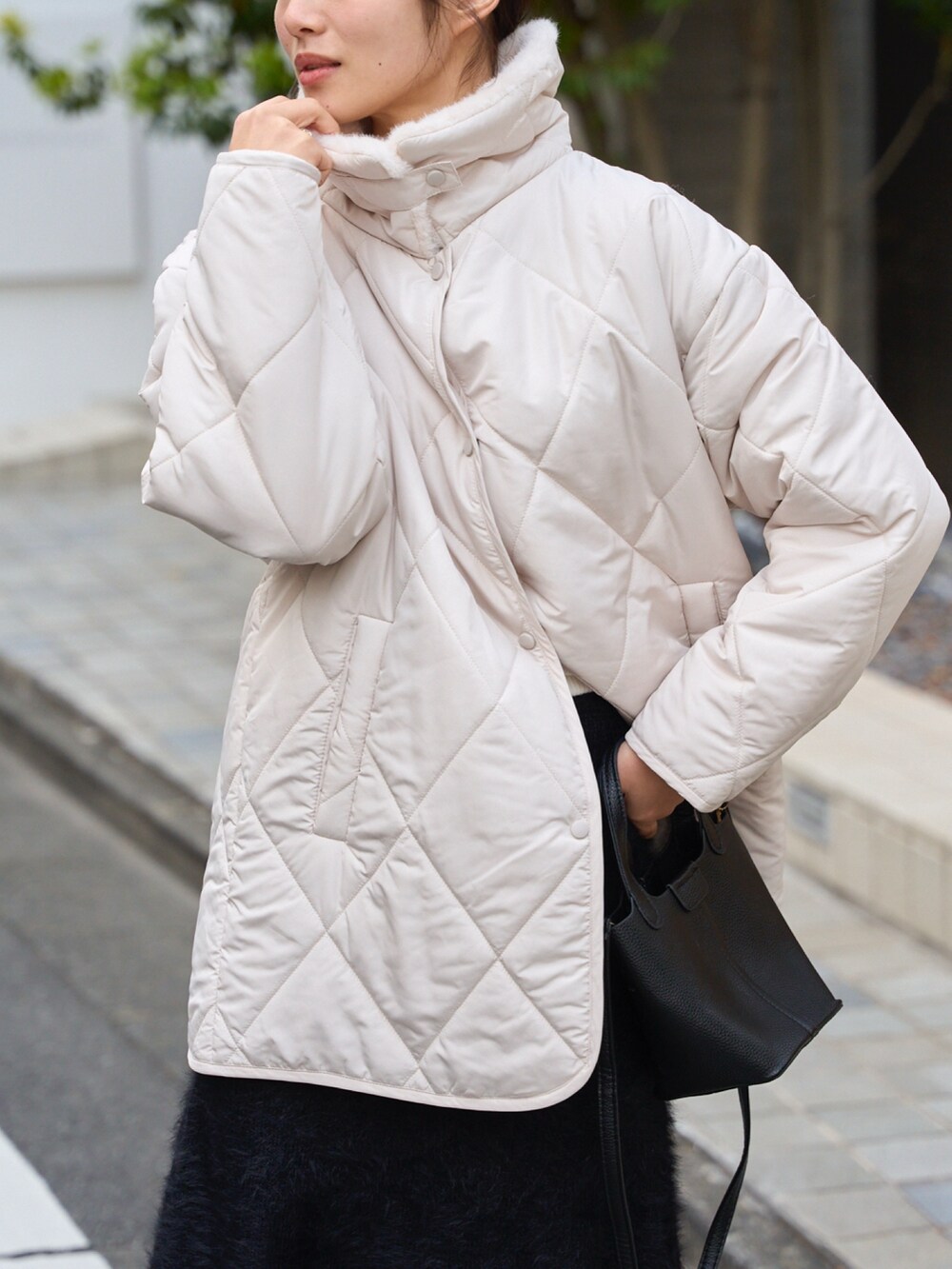 ホワイト系のその他アウター、ブラック系のスカートを着用したレディースの冬コーディネートの3枚目の写真