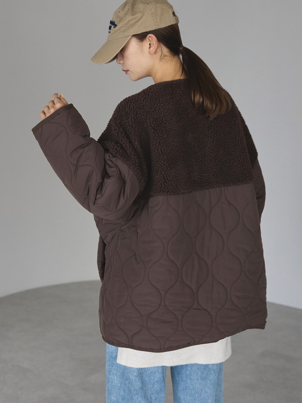 ブラウン系のノーカラージャケットを着用したレディースの冬コーディネートの5枚目の写真