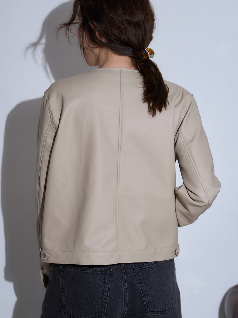 ホワイト系のライダースジャケットを着用したレディースの春コーディネートの5枚目の写真