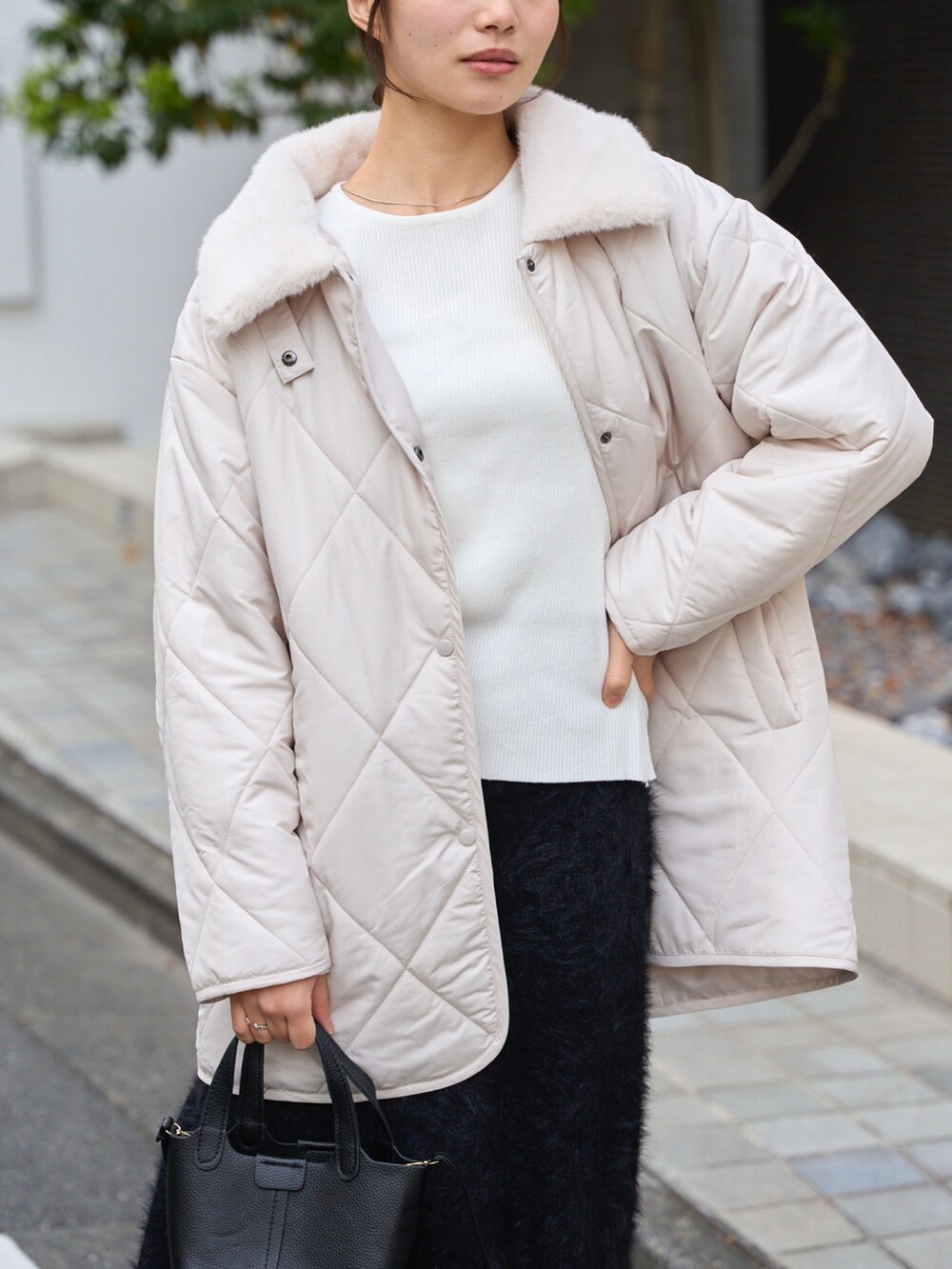 ホワイト系のその他アウター、ブラック系のスカートを着用したレディースの冬コーディネートの4枚目の写真