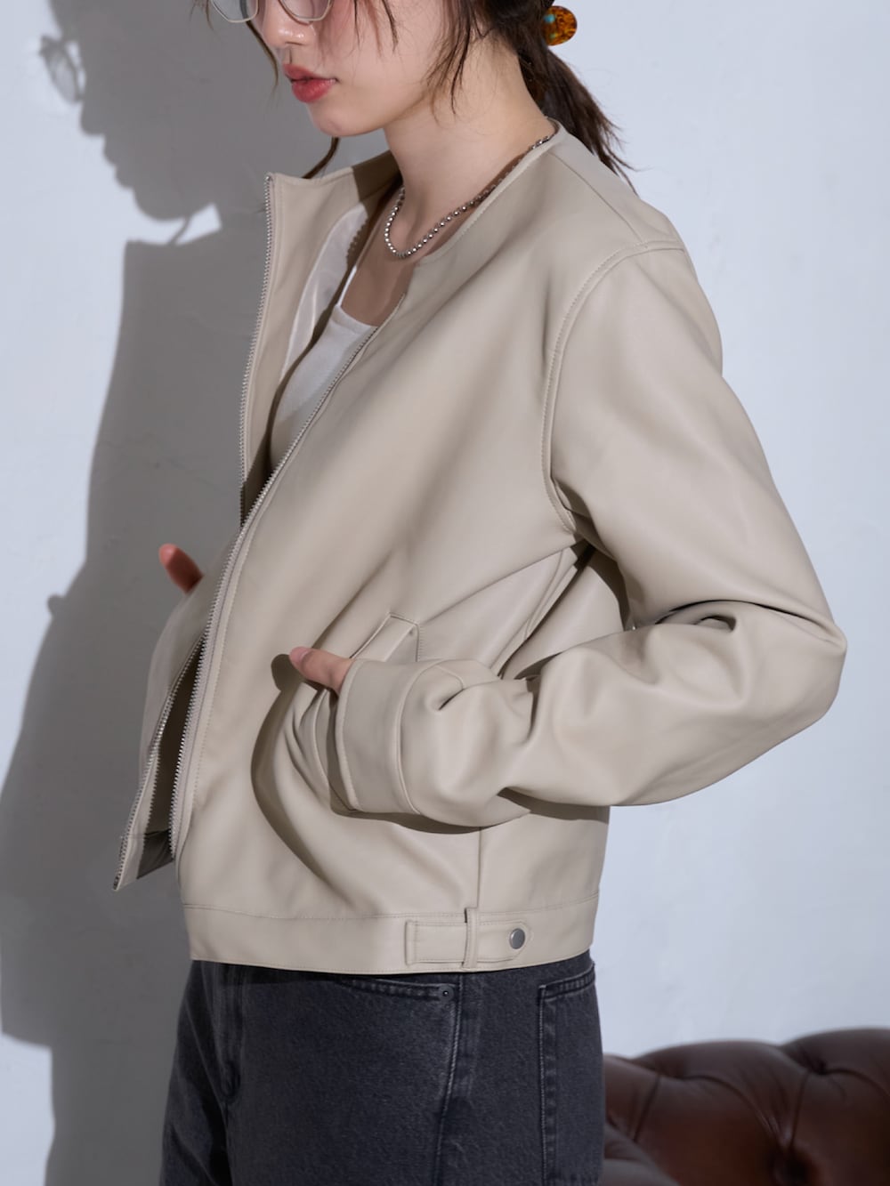 ホワイト系のライダースジャケットを着用したレディースの春コーディネートの4枚目の写真