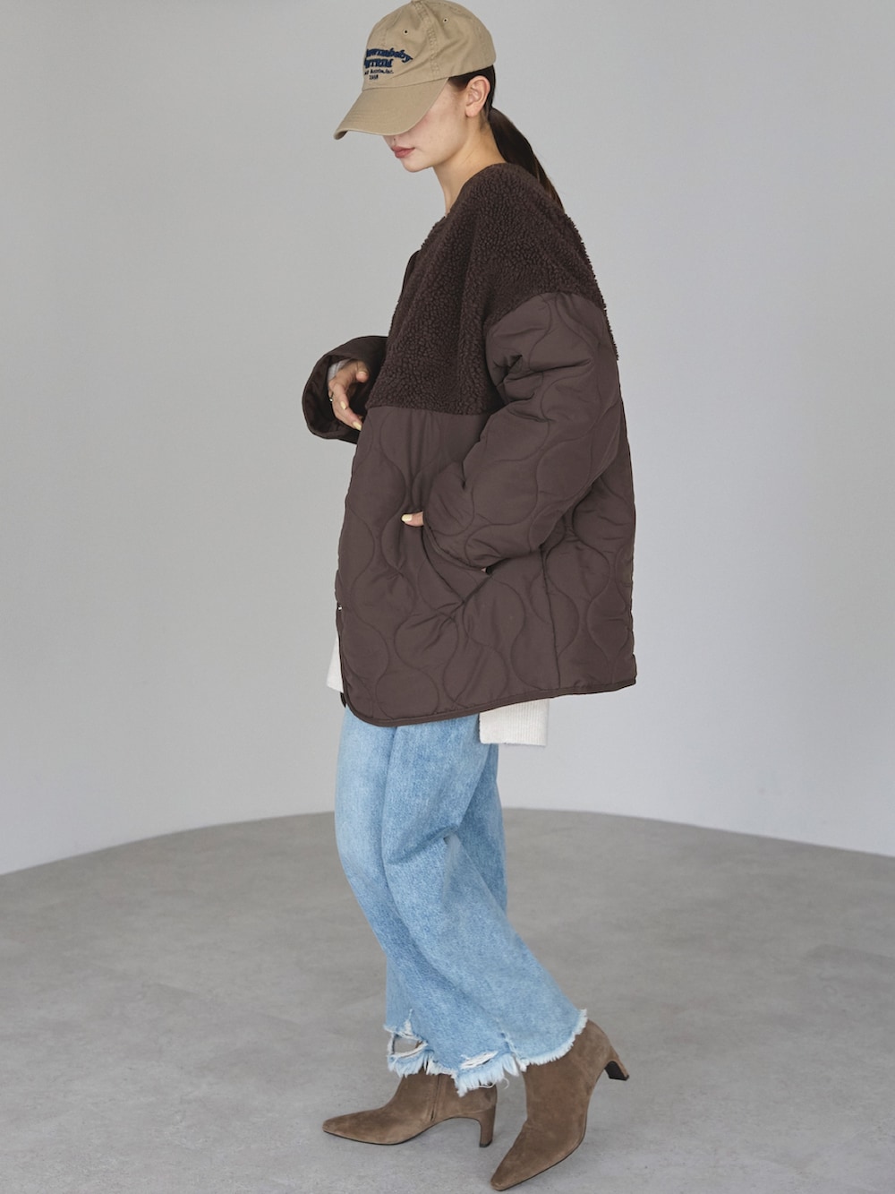 ブラウン系のノーカラージャケットを着用したレディースの冬コーディネートの3枚目の写真