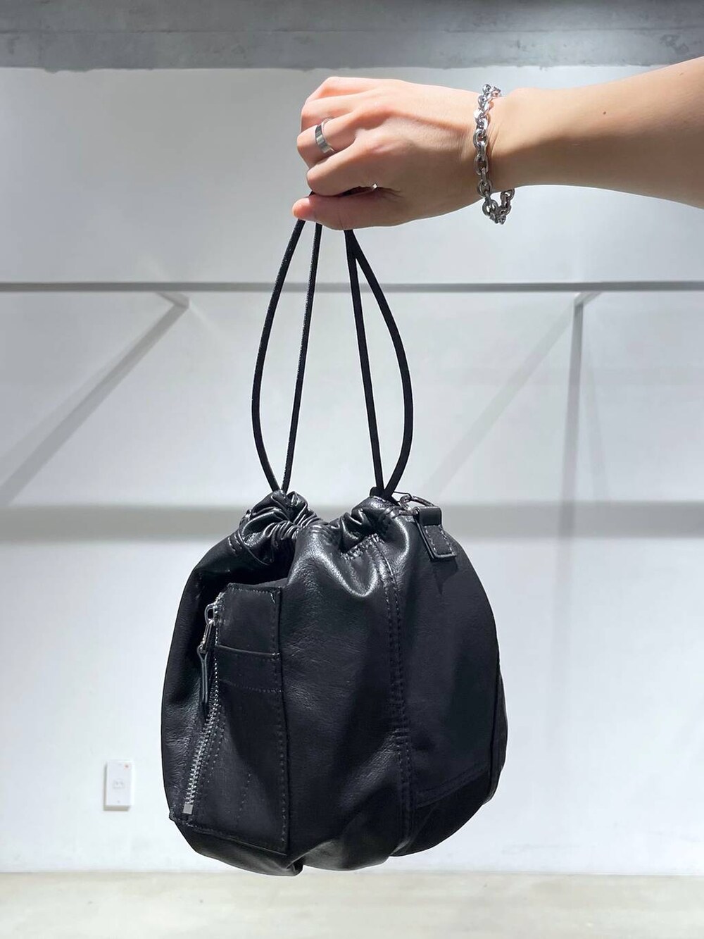ブラック系のショルダーバッグ、ホワイト系のタンクトップ、その他のスラックスを着用したメンズの夏コーディネートの5枚目の写真