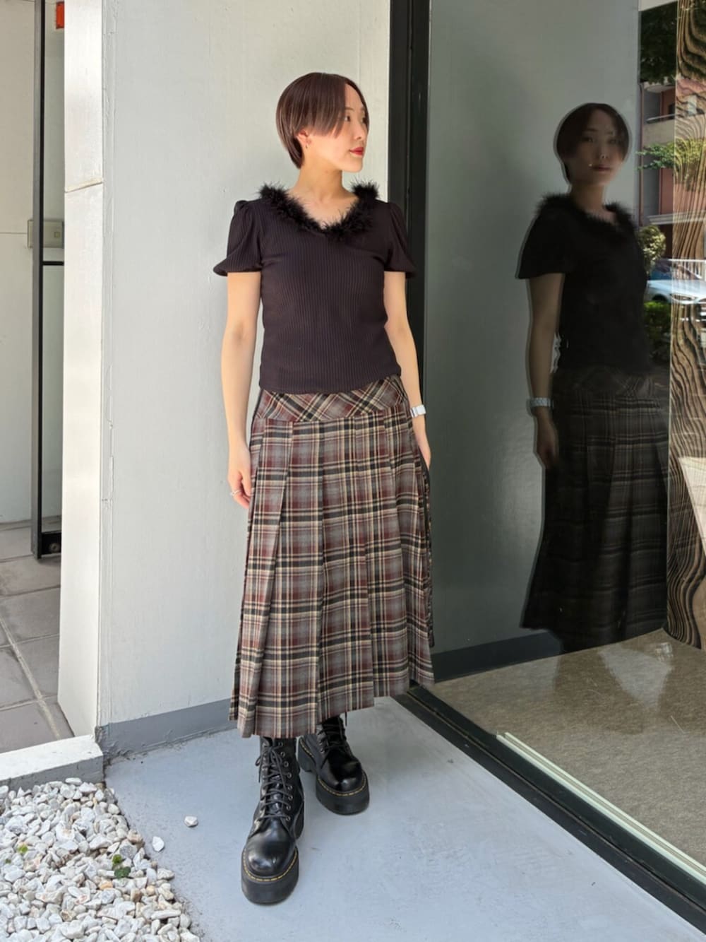 ブラック系のムートンコート、ブラック系のTシャツ/カットソー、レッド系のスカートを着用したレディースの秋コーディネートの5枚目の写真