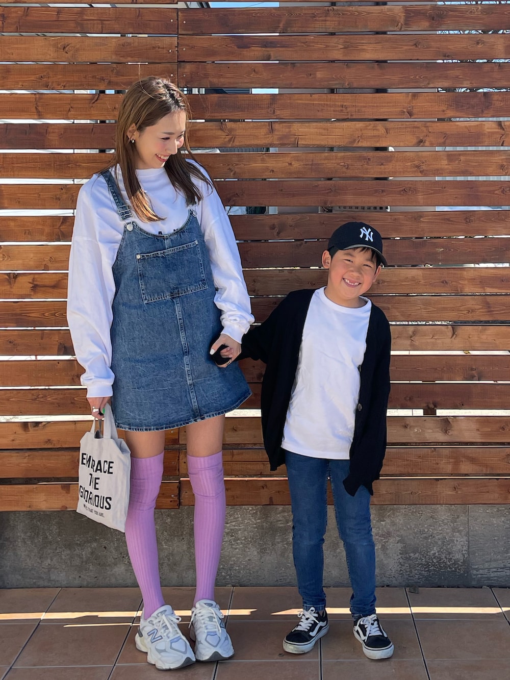 ブラック系のカーディガン/ボレロ、ブラック系のスニーカー、オレンジ系のTシャツ/カットソーを着用したキッズの春コーディネートの2枚目の写真