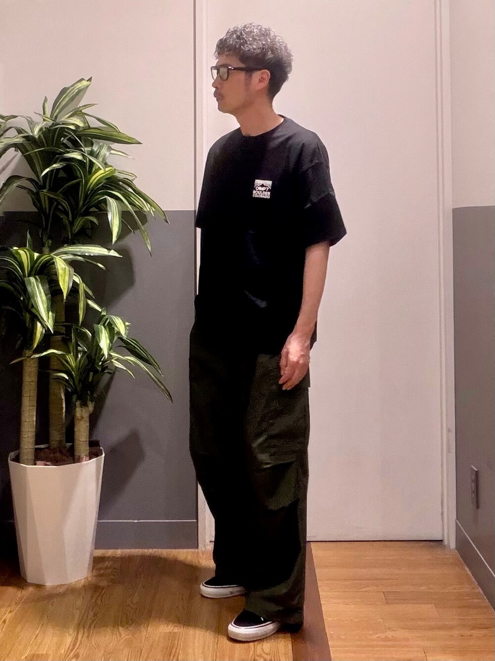 グリーン系のその他パンツ、ブラック系のTシャツ/カットソーを着用したメンズの夏コーディネートの2枚目の写真