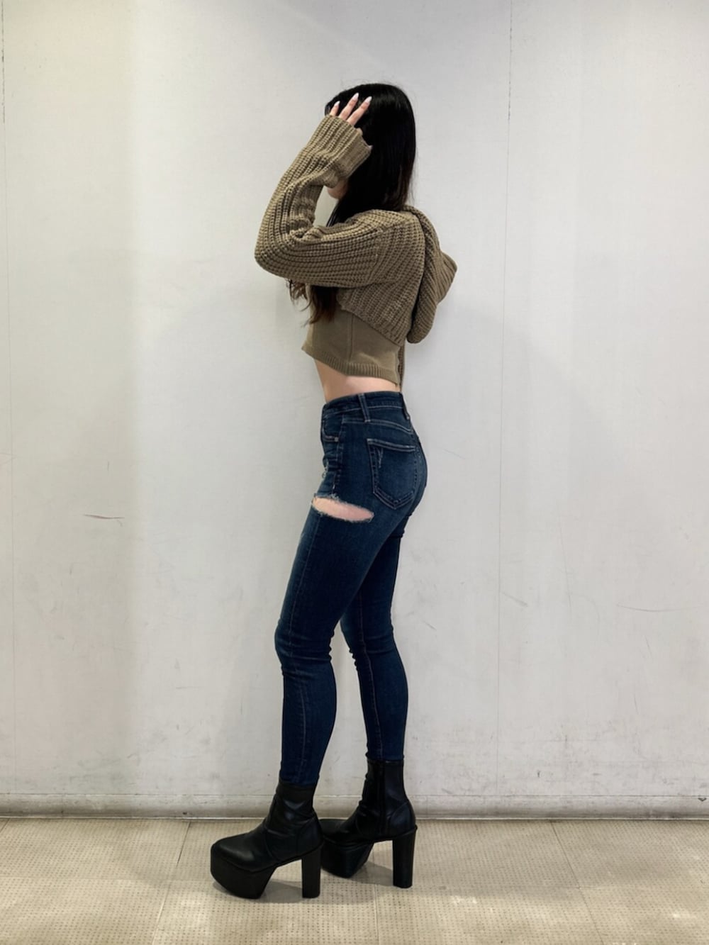 ホワイト系のニット/セーター、ブルー系のデニムパンツ、ブラック系のブーツを着用したレディースの秋コーディネートの2枚目の写真