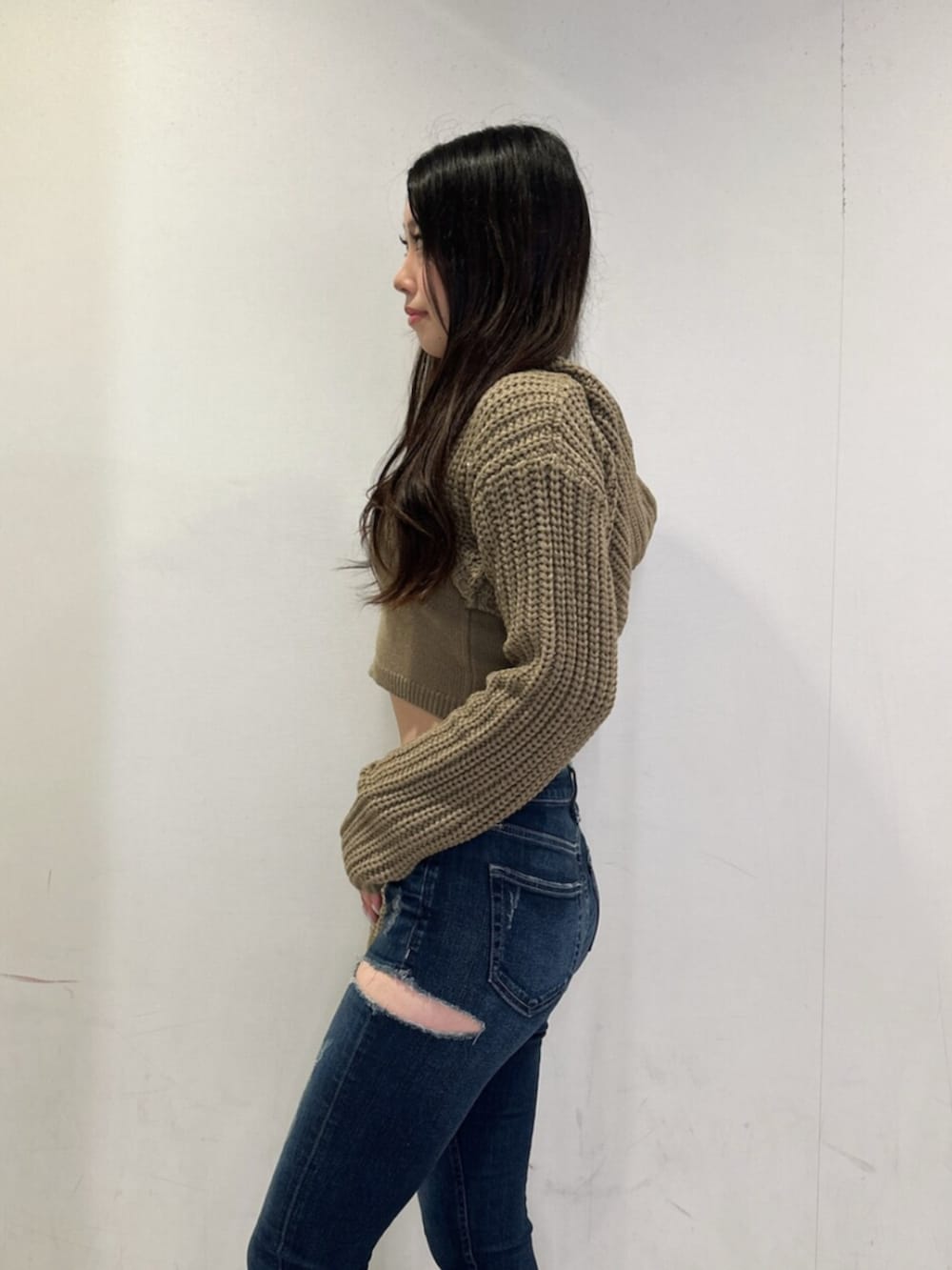 ホワイト系のニット/セーター、ブルー系のデニムパンツ、ブラック系のブーツを着用したレディースの秋コーディネートの5枚目の写真