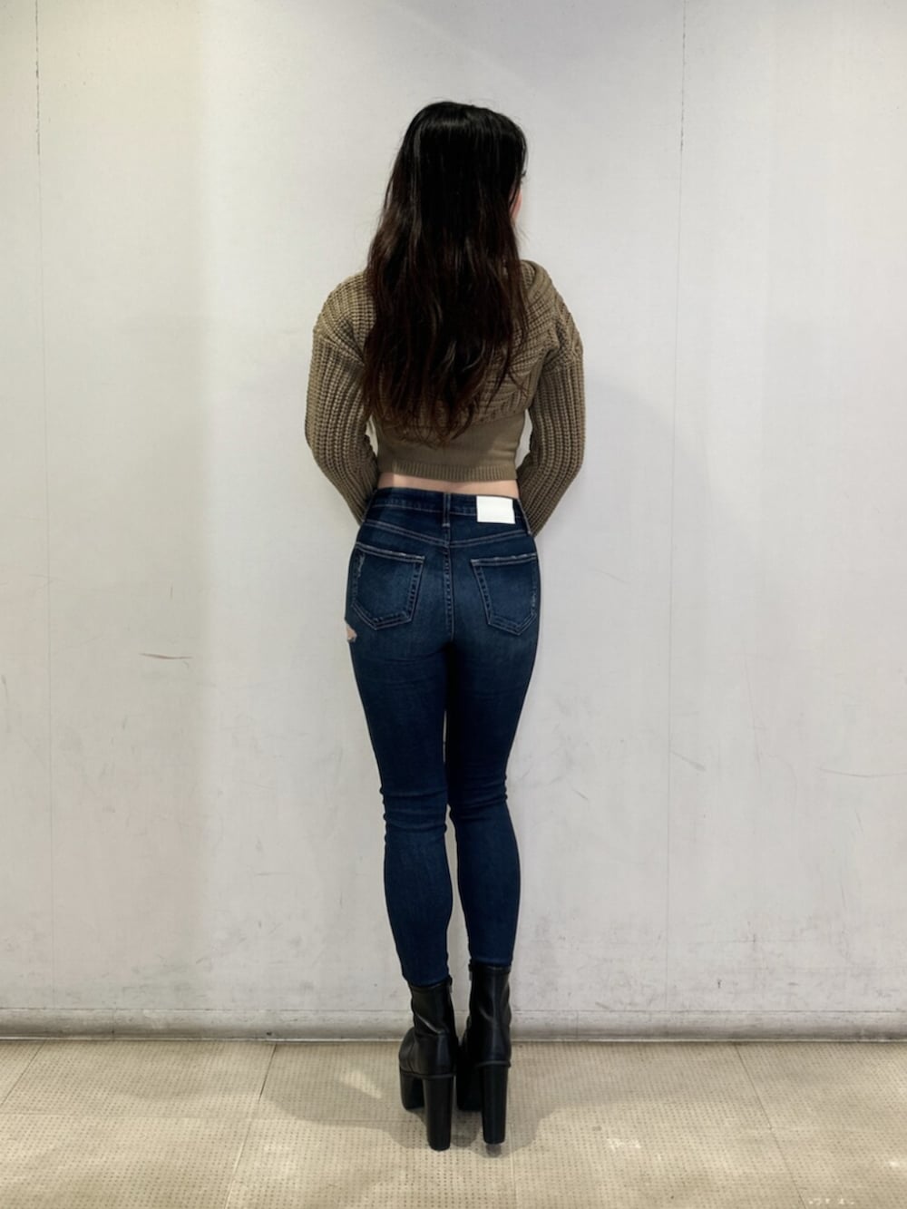 ホワイト系のニット/セーター、ブルー系のデニムパンツ、ブラック系のブーツを着用したレディースの秋コーディネートの3枚目の写真
