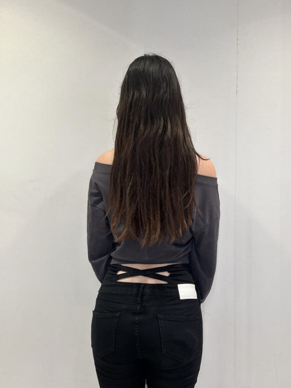 ブラック系のデニムパンツ、グレー系のスウェット、ブラック系のブーツを着用したレディースの秋コーディネートの5枚目の写真