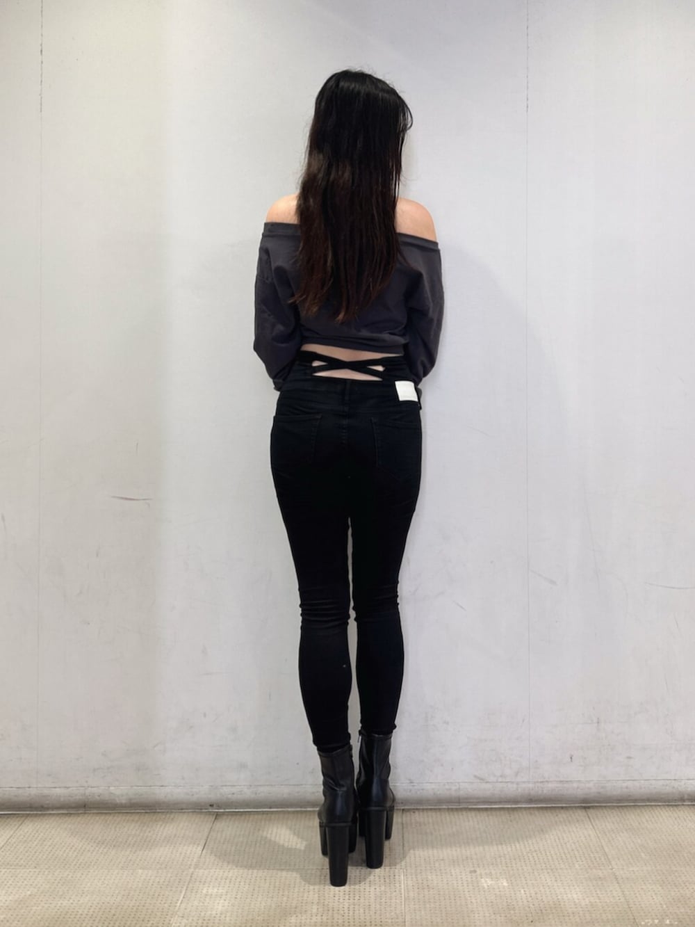 ブラック系のデニムパンツ、グレー系のスウェット、ブラック系のブーツを着用したレディースの秋コーディネートの3枚目の写真