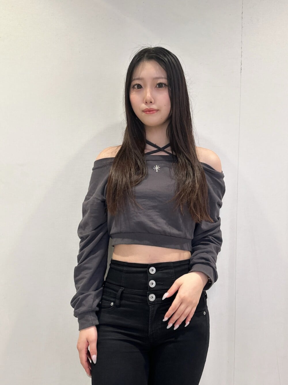ブラック系のデニムパンツ、グレー系のスウェット、ブラック系のブーツを着用したレディースの秋コーディネートの4枚目の写真