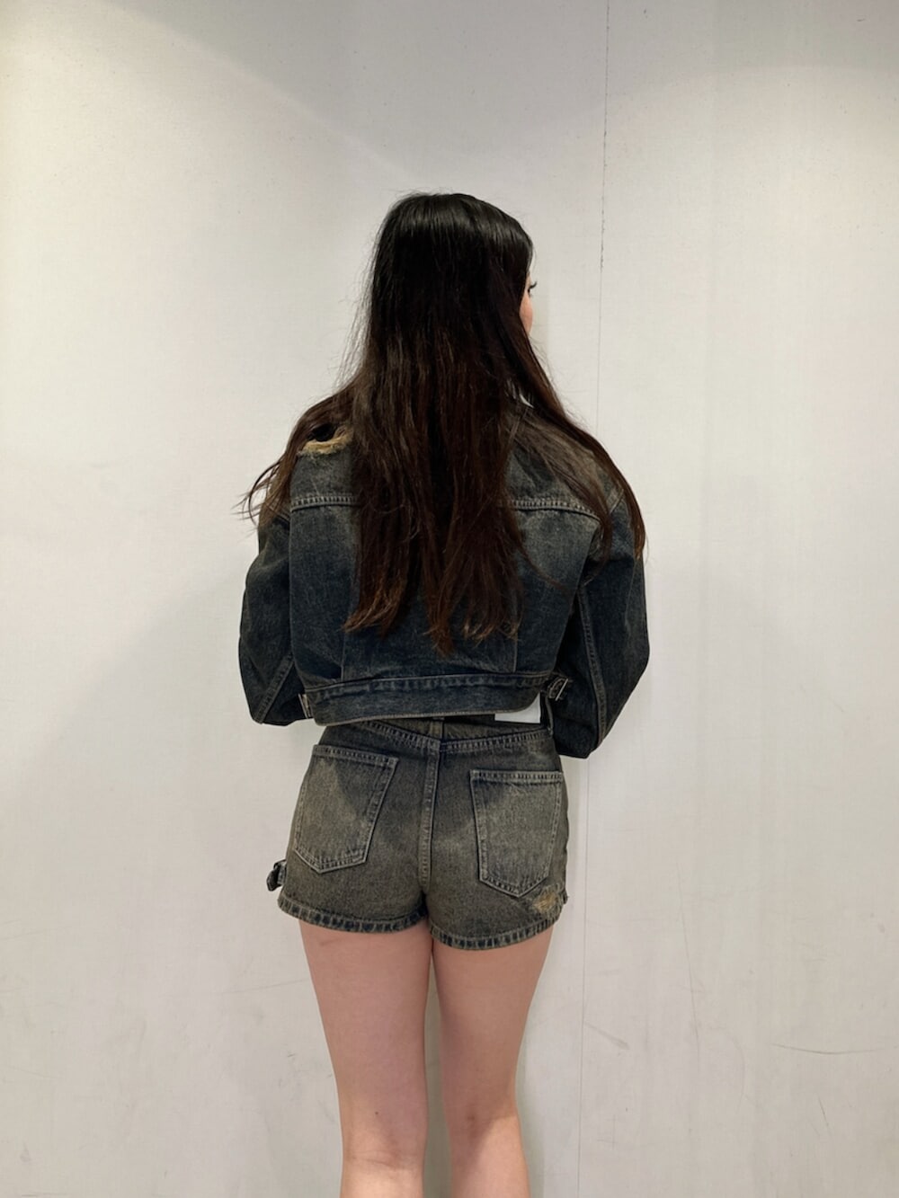 ブルー系のデニムジャケット、ブルー系のデニムパンツ、ブラック系のニット/セーターを着用したレディースの秋コーディネートの5枚目の写真