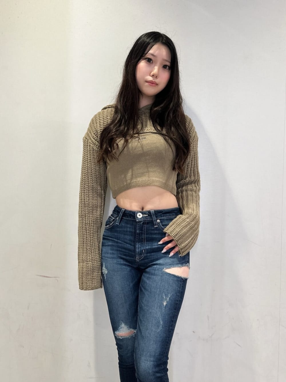 ホワイト系のニット/セーター、ブルー系のデニムパンツ、ブラック系のブーツを着用したレディースの秋コーディネートの4枚目の写真
