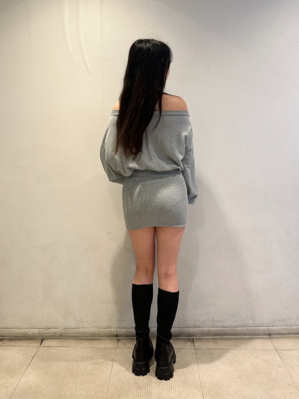 グレー系のワンピース、ブラック系のブーツを着用したレディースの秋コーディネートの3枚目の写真