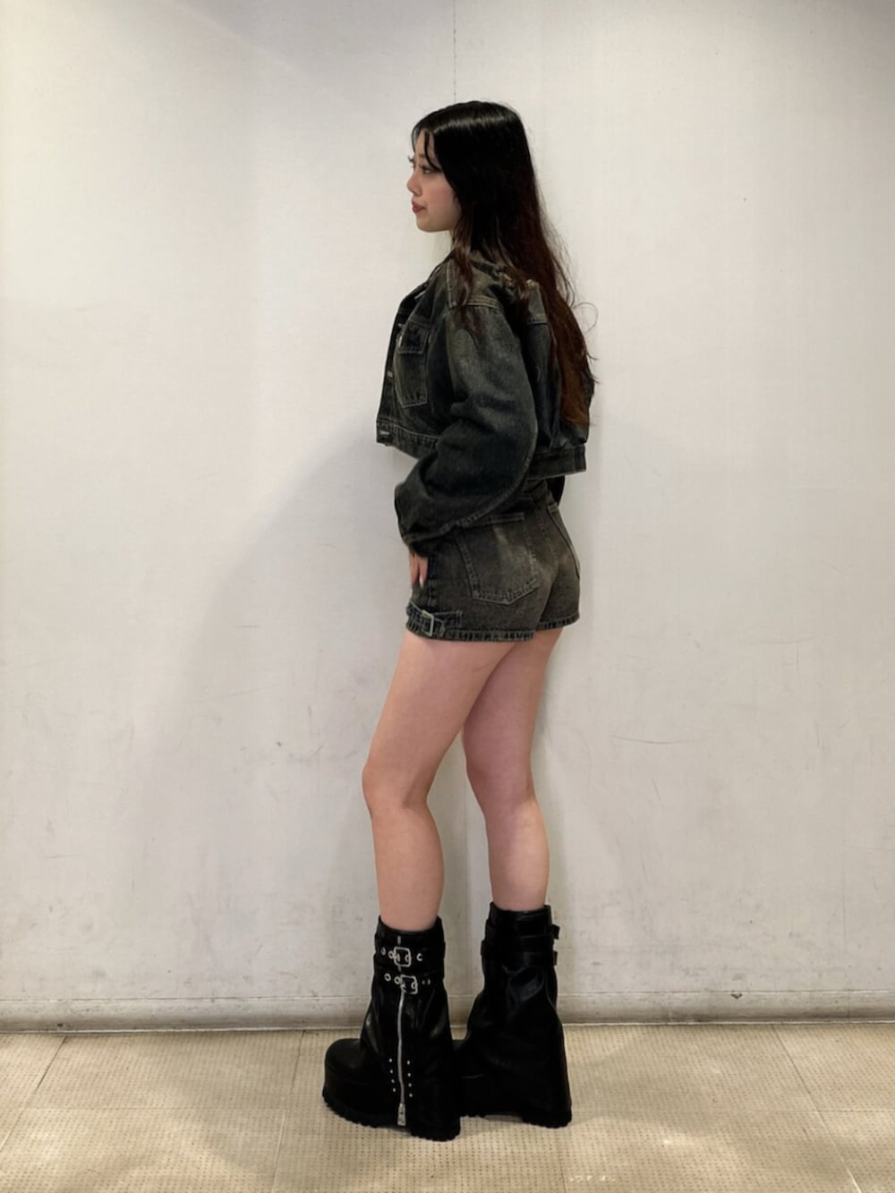 ブルー系のデニムジャケット、ブルー系のデニムパンツ、ブラック系のニット/セーターを着用したレディースの秋コーディネートの2枚目の写真