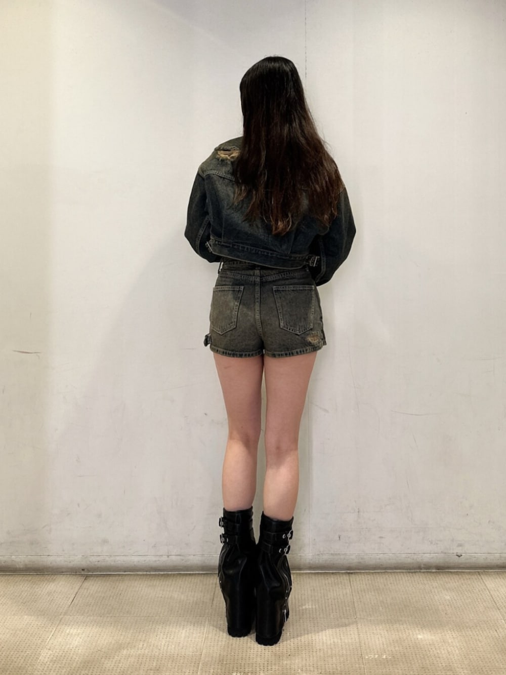 ブルー系のデニムジャケット、ブルー系のデニムパンツ、ブラック系のニット/セーターを着用したレディースの秋コーディネートの3枚目の写真