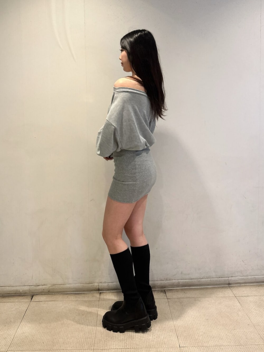 グレー系のワンピース、ブラック系のブーツを着用したレディースの秋コーディネートの2枚目の写真