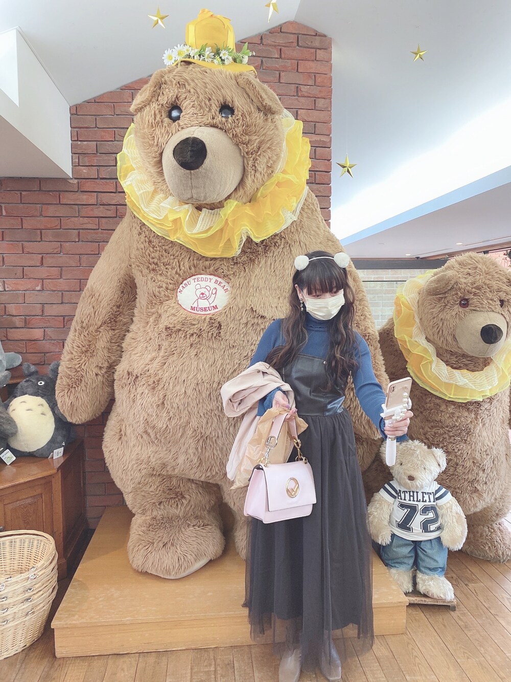 ブラウン系のワンピース/ドレス、ブルー系のニット/セーター、ピンク系のライダースジャケットを着用したレディースの冬コーディネートの3枚目の写真