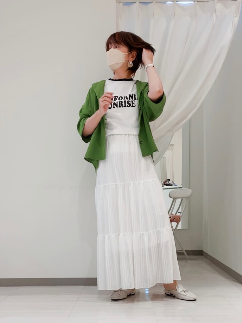 グリーン系のシャツ/ブラウス、ホワイト系のスカート、ホワイト系のその他シューズを着用したレディースの春コーディネートの4枚目の写真