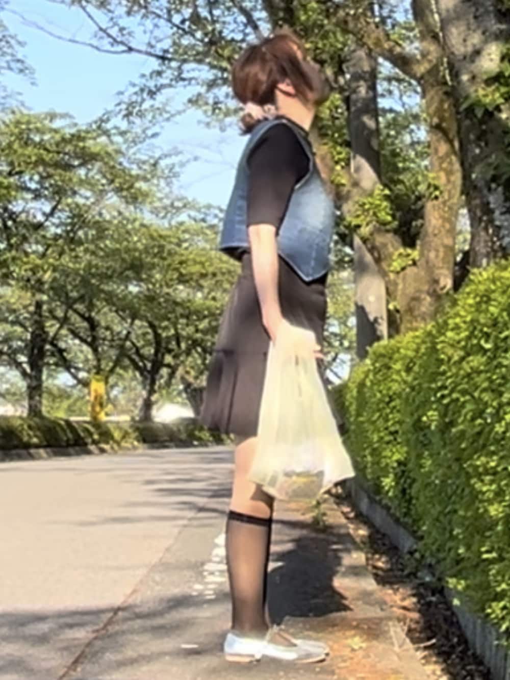 ブルー系のベスト、ブラック系のスカート、シルバー系のバレエシューズを着用したレディースの春コーディネートの2枚目の写真