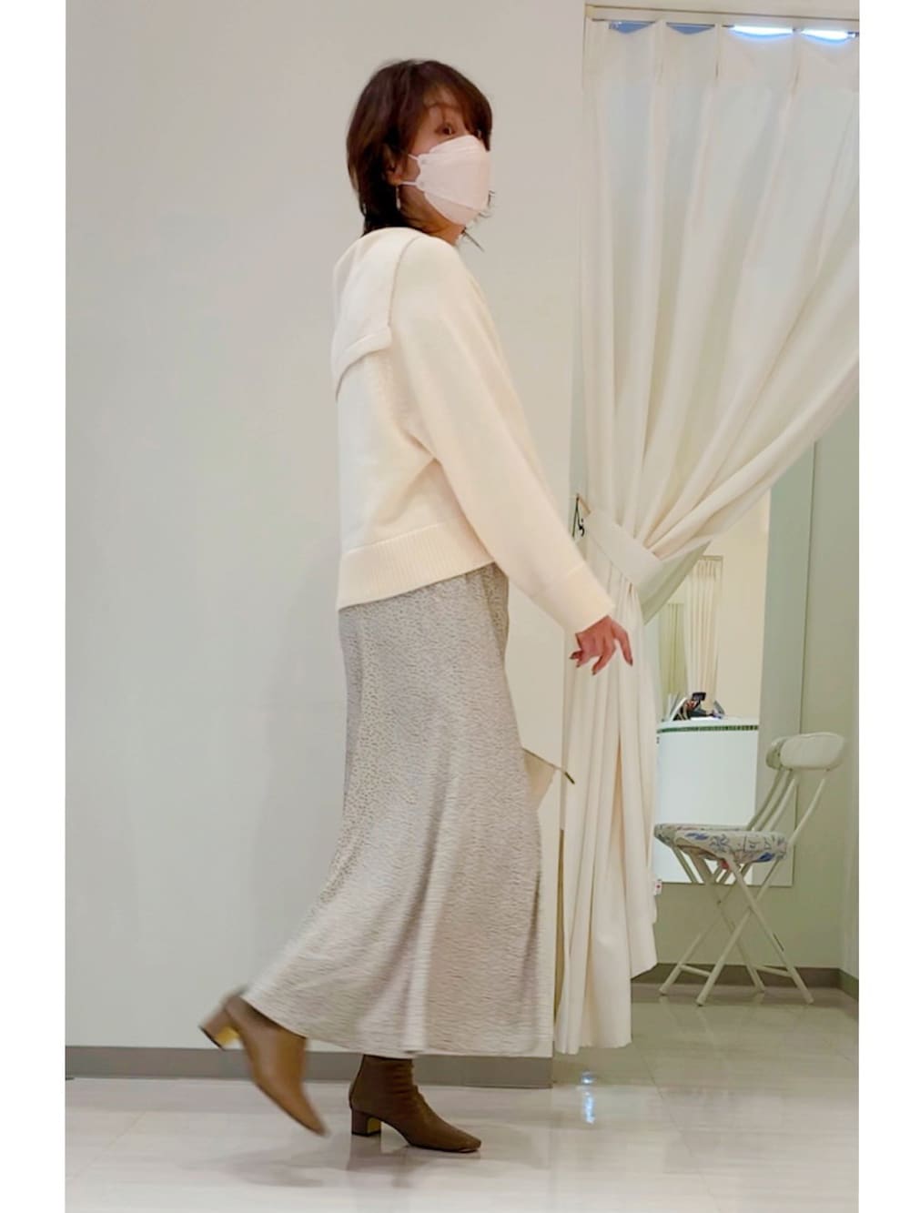 ホワイト系のニット/セーター、ベージュ系のスカート、ブラウン系のブーツを着用したレディースの秋コーディネートの3枚目の写真