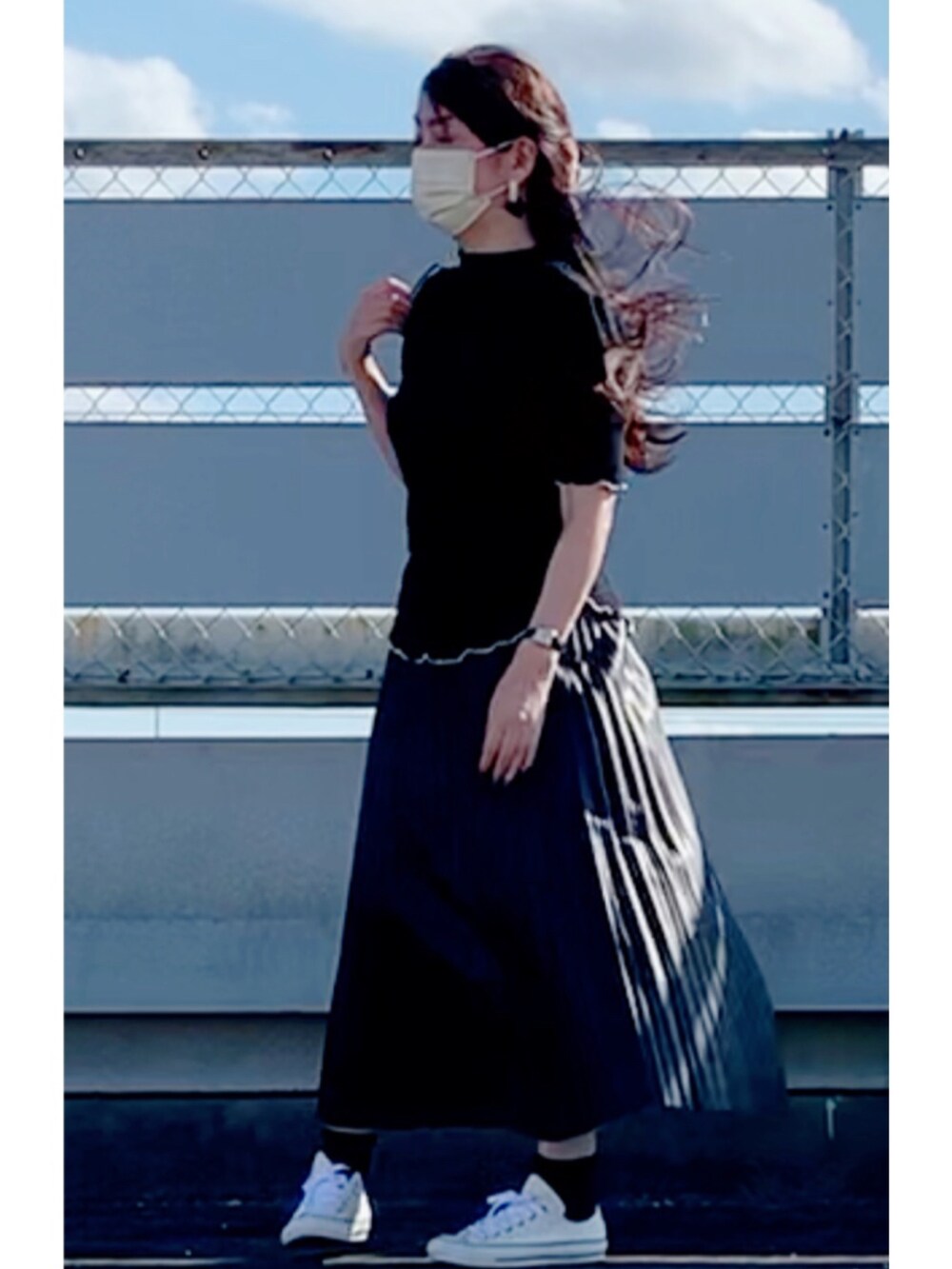 ブラック系のスカート、ホワイト系のスニーカー、ブラック系のショルダーバッグを着用したレディースの秋コーディネートの2枚目の写真