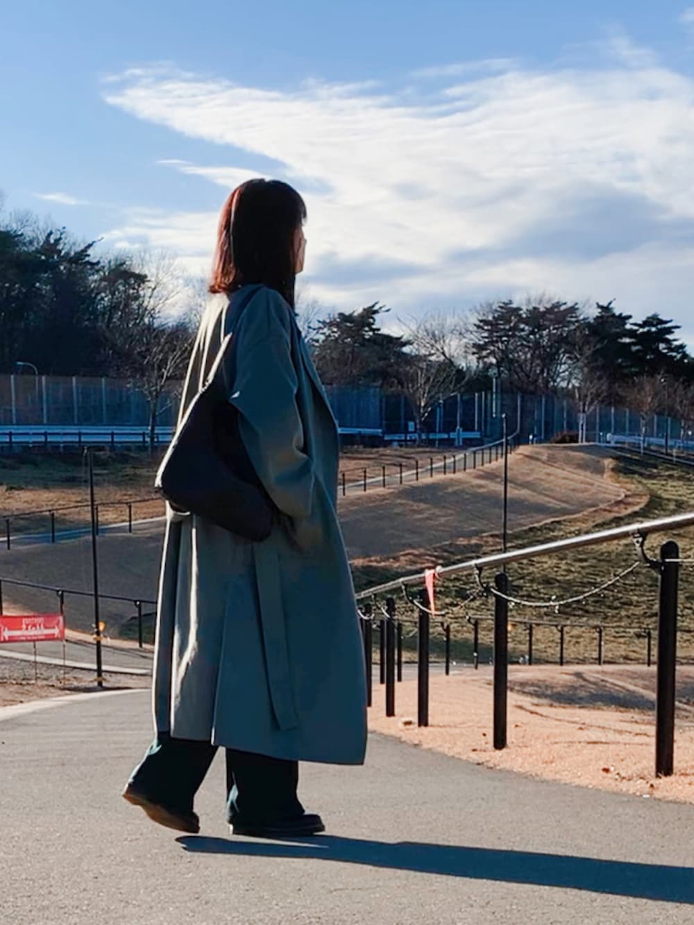 グリーン系のチェスターコート、ブラック系のドレスシューズ、ホワイト系のシャツ/ブラウスを着用したレディースの冬コーディネートの2枚目の写真