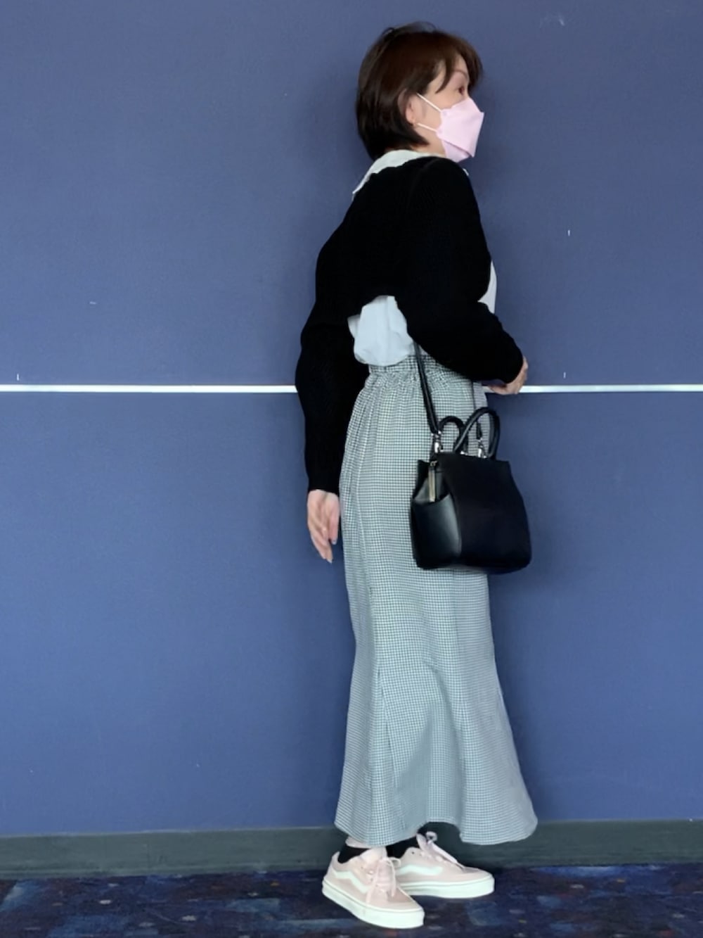 ピンク系のスニーカー、ブラック系のスカート、ブラック系のカーディガン/ボレロを着用したレディースの春コーディネートの2枚目の写真