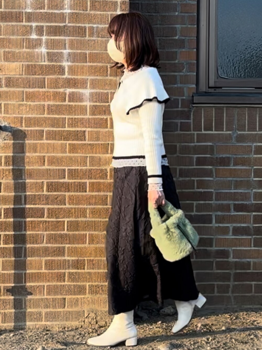 ホワイト系のブーツ、ホワイト系のニット/セーター、ホワイト系のシャツ/ブラウスを着用したレディースの冬コーディネートの2枚目の写真