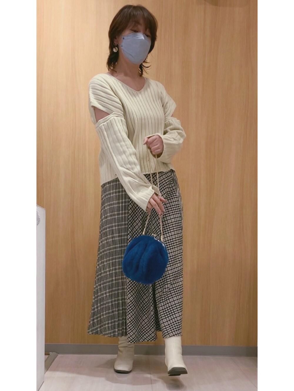 ホワイト系のブーツ、ブルー系のショルダーバッグ、その他のスカートを着用したレディースの秋コーディネートの3枚目の写真