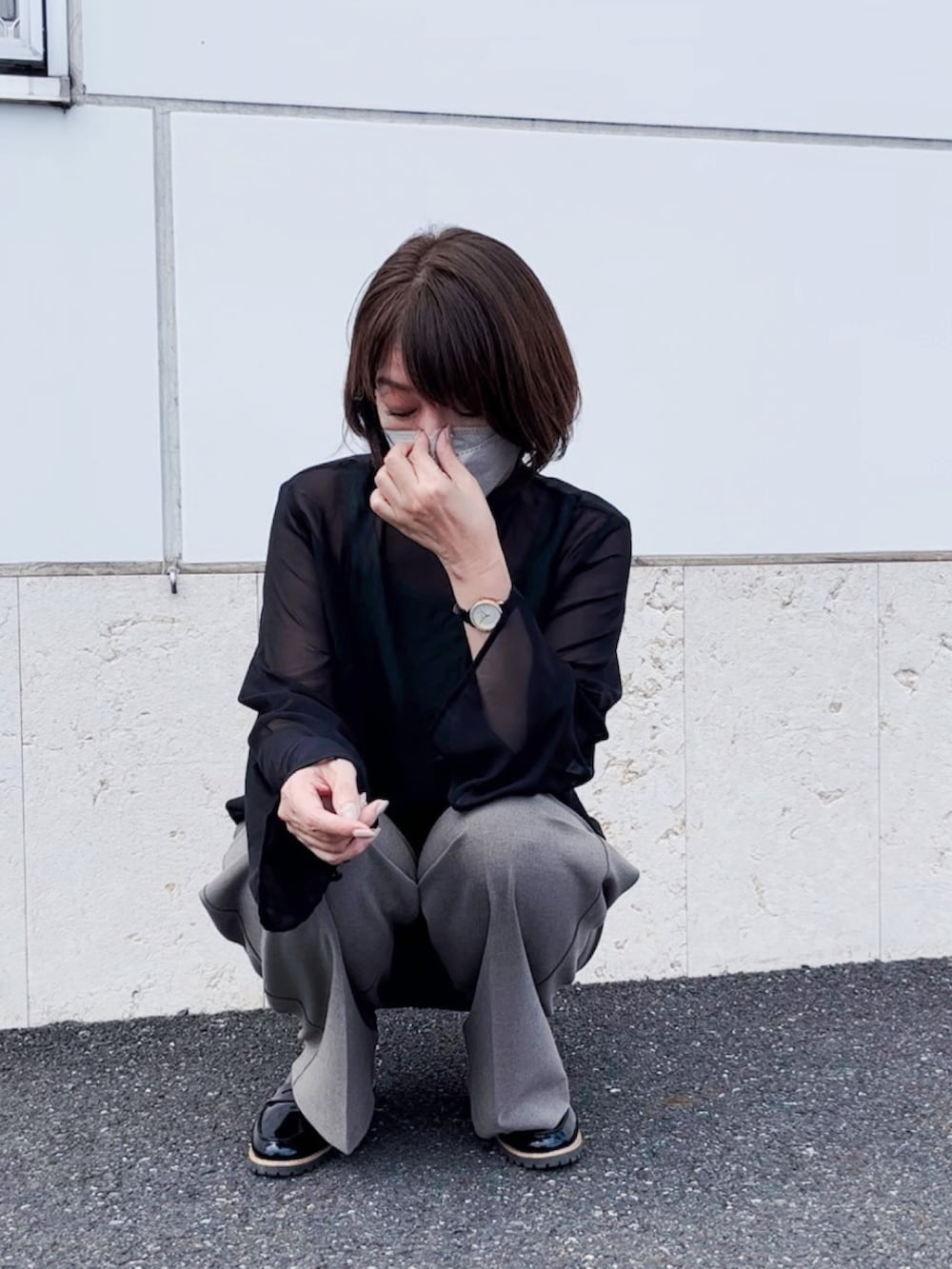 ブラウン系のバッグ、ブラウン系のスラックス、ブラック系のシャツ/ブラウスを着用したレディースの秋コーディネートの3枚目の写真