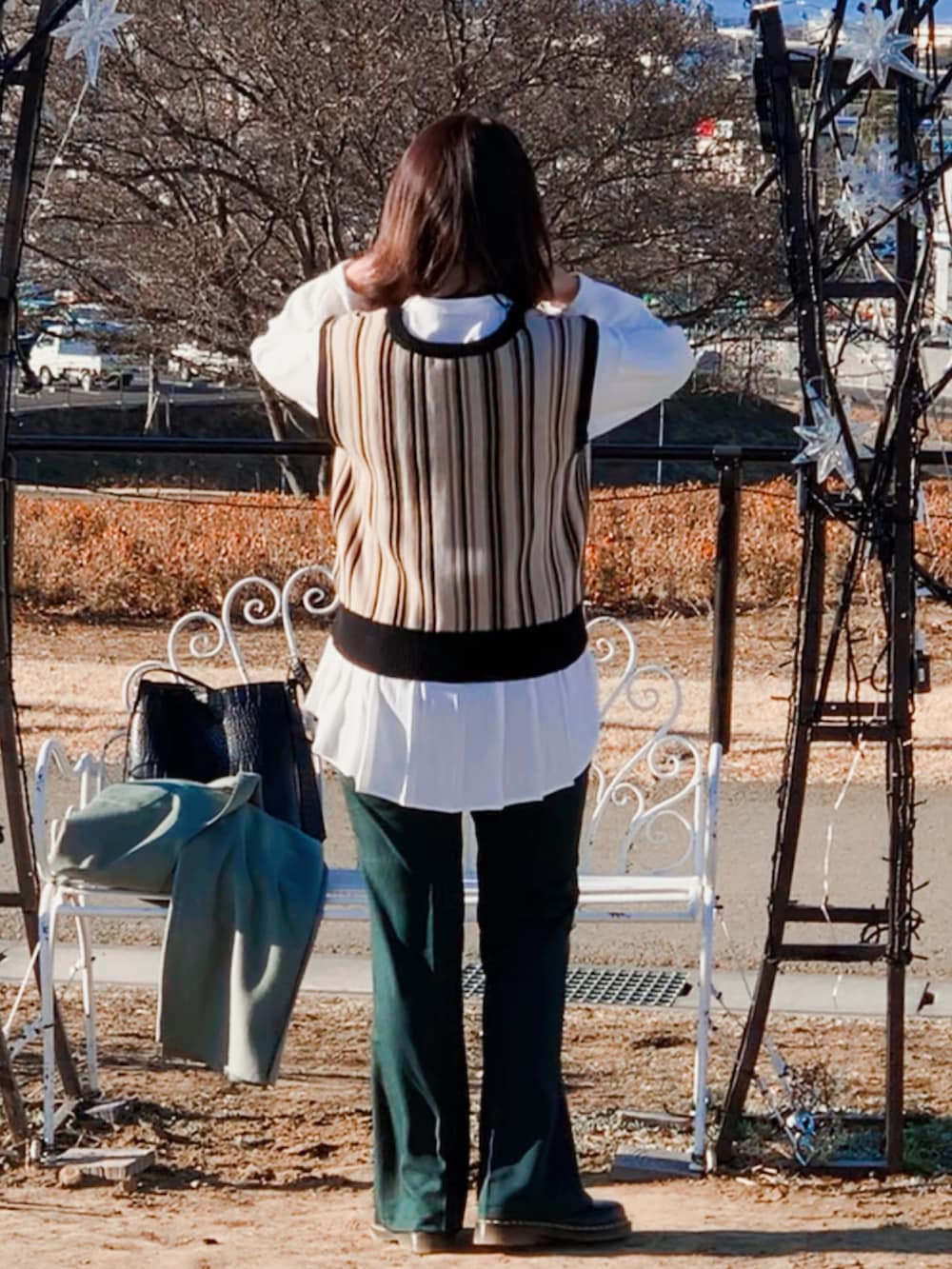 グリーン系のチェスターコート、ブラック系のドレスシューズ、ホワイト系のシャツ/ブラウスを着用したレディースの冬コーディネートの3枚目の写真