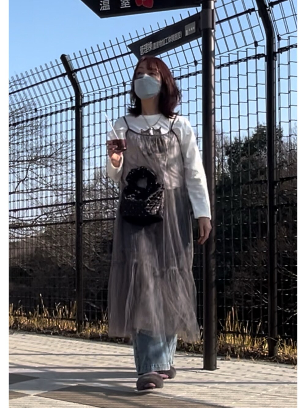 ブラック系のトートバッグ、グレー系のワンピース、ホワイト系のTシャツ/カットソーを着用したレディースの春コーディネートの2枚目の写真