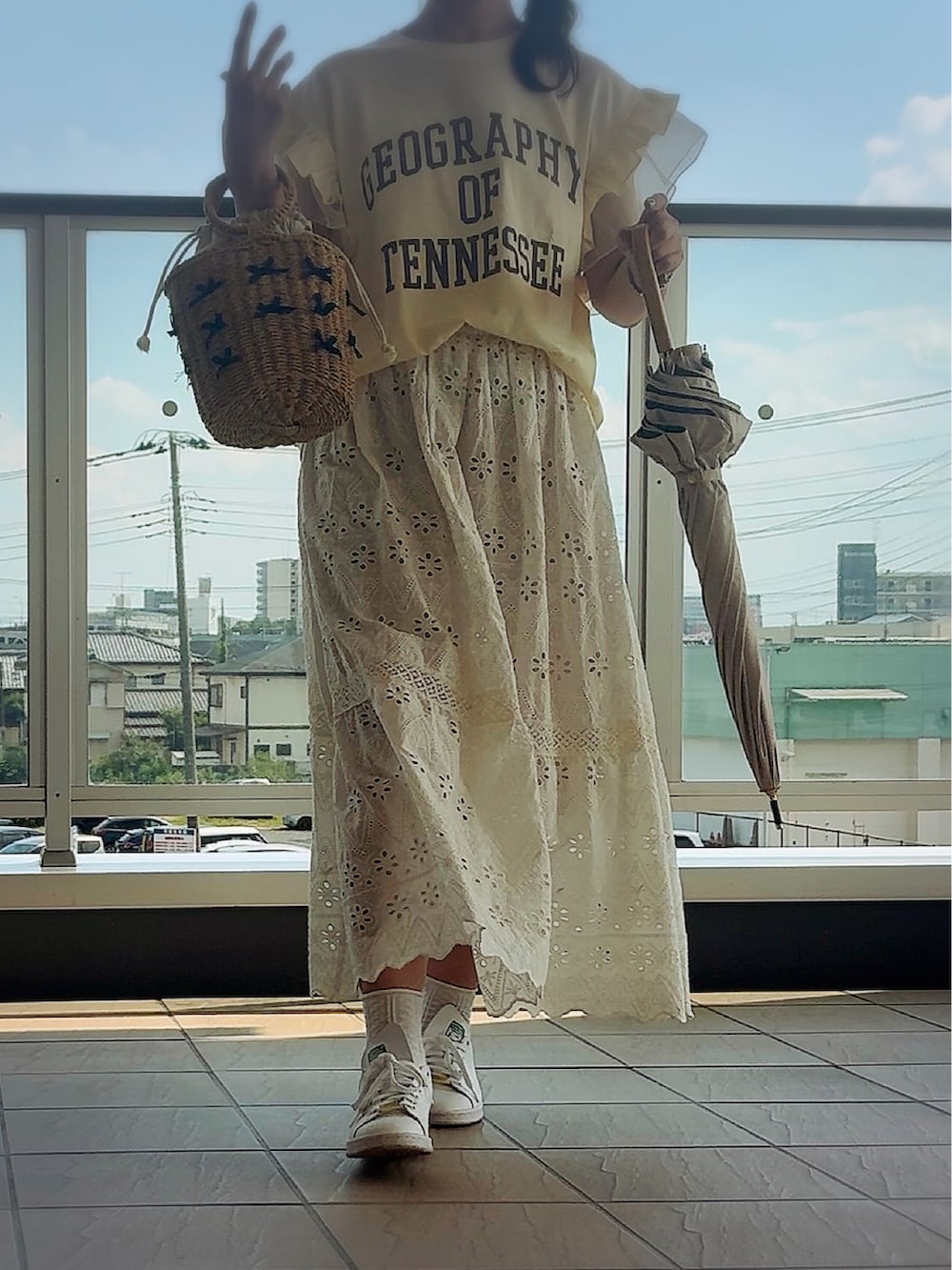 イエロー系のTシャツ/カットソー、ホワイト系のスカート、ベージュ系のかごバッグを着用したレディースの夏コーディネートの2枚目の写真