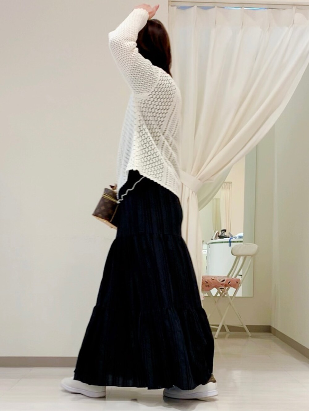 ホワイト系のニット/セーター、ブラウン系のボディバッグ/ウエストポーチ、ブラック系のスカートを着用したレディースの春コーディネートの5枚目の写真