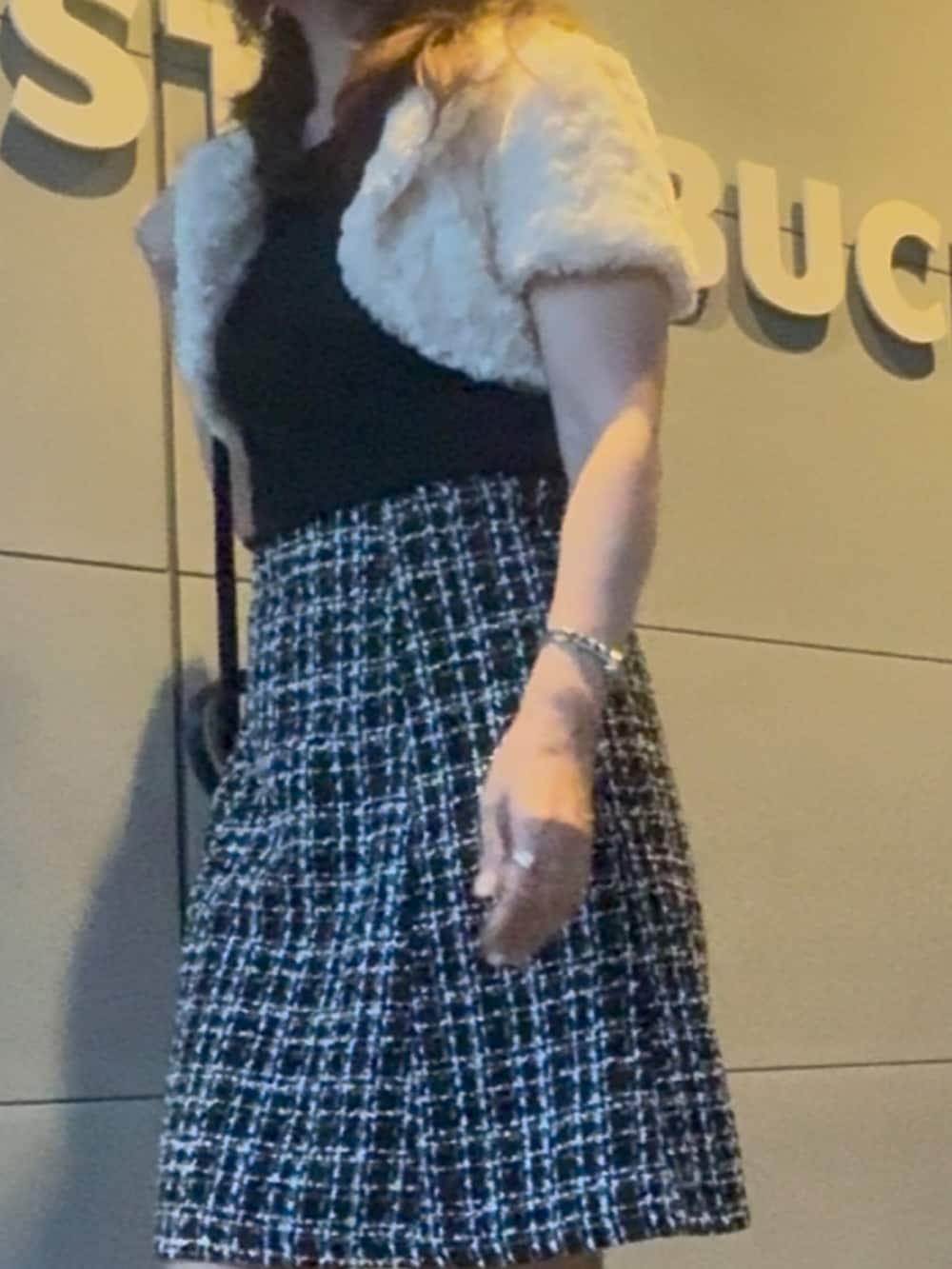 ブラック系のショルダーバッグ、ブラック系のブーツ、ブラック系のスカートを着用したレディースの秋コーディネートの2枚目の写真