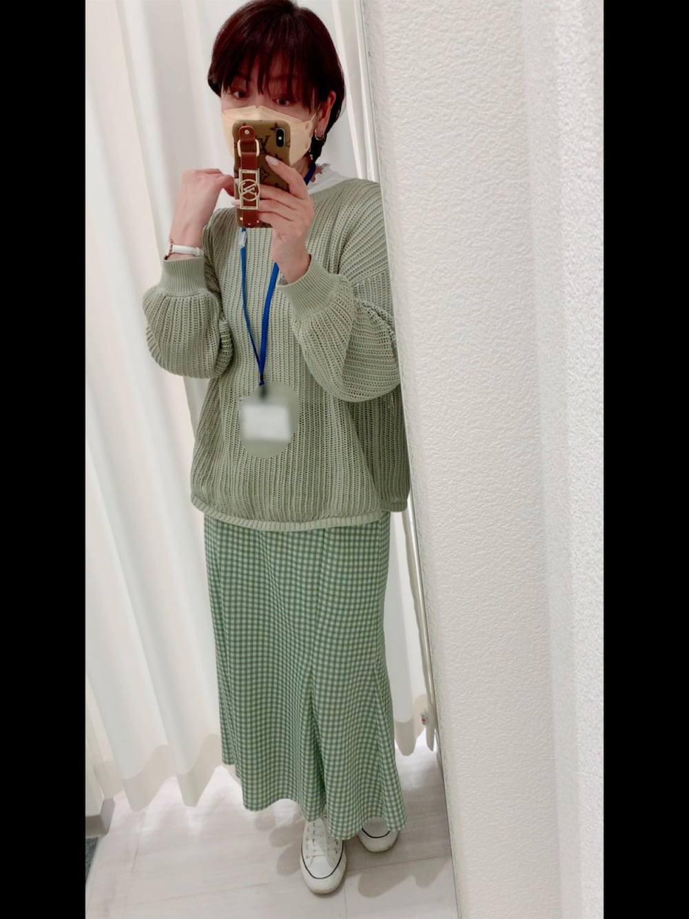 ホワイト系のスニーカー、グリーン系のニット/セーター、ホワイト系のデニムジャケットを着用したレディースの春コーディネートの2枚目の写真