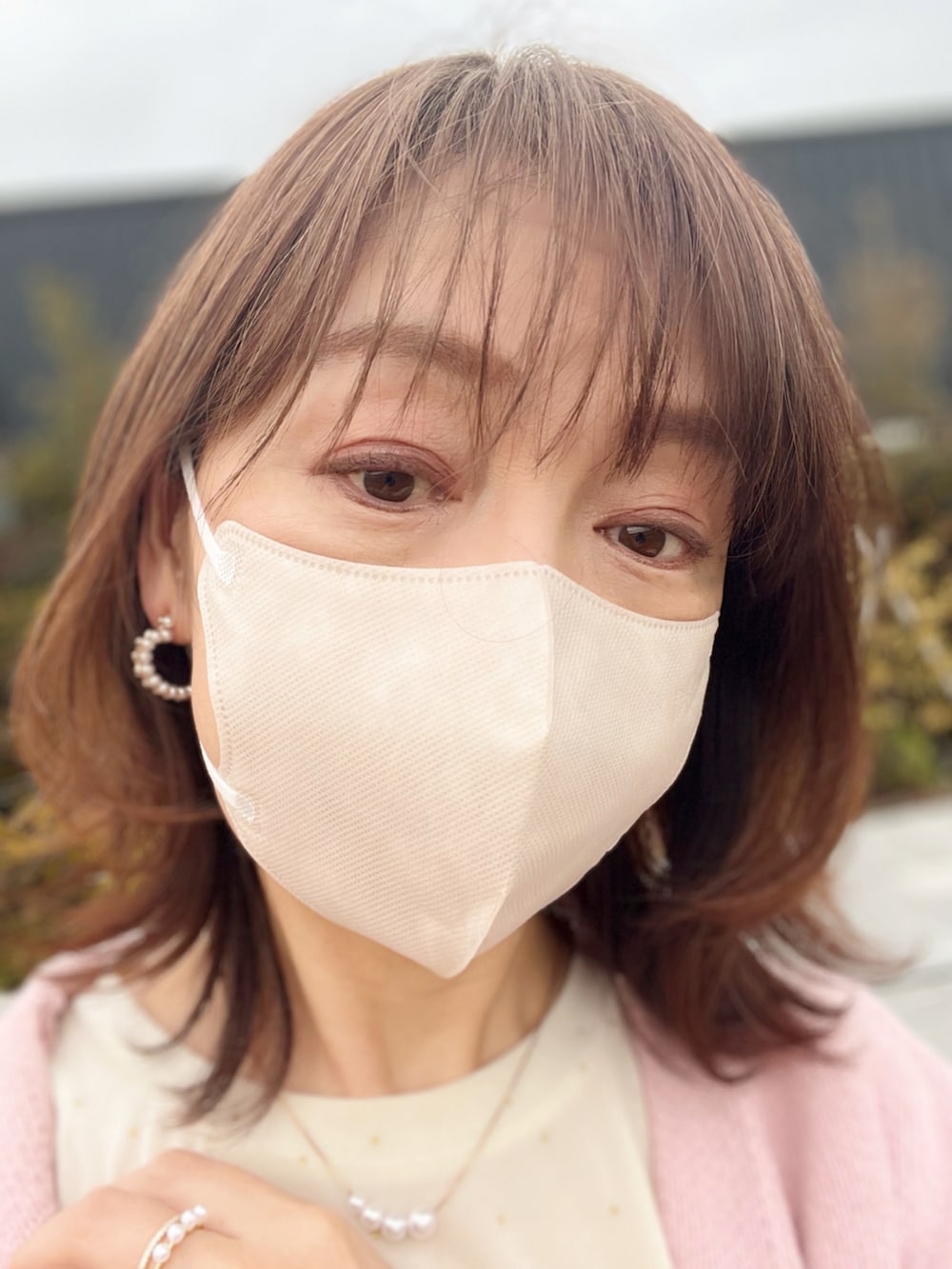 ピンク系のカーディガン/ボレロ、ブラック系のスカート、ホワイト系のショルダーバッグを着用したレディースの冬コーディネートの3枚目の写真