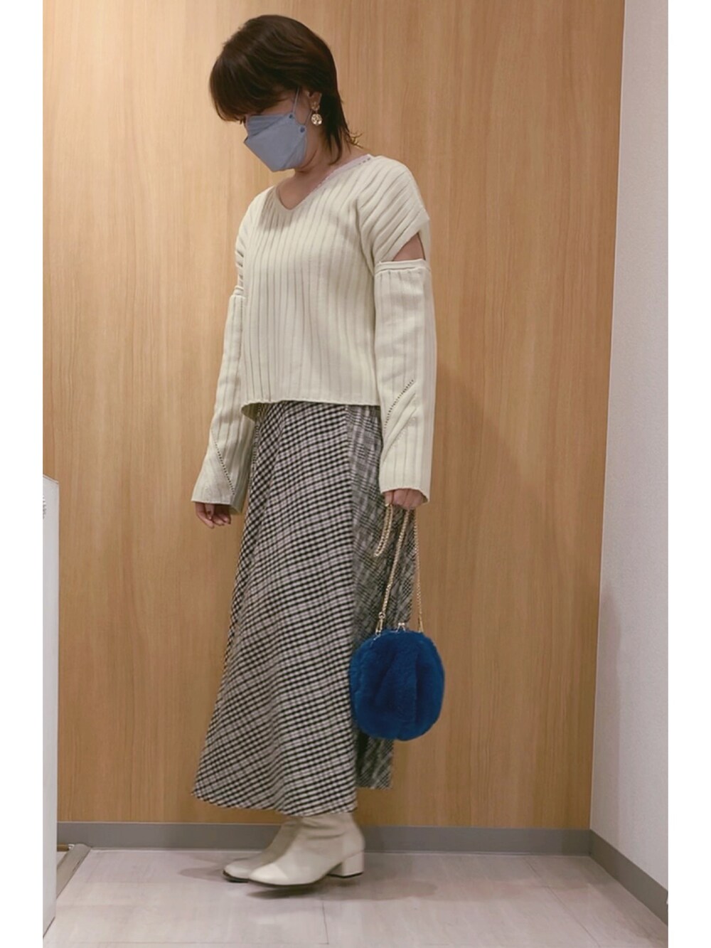 ホワイト系のブーツ、ブルー系のショルダーバッグ、その他のスカートを着用したレディースの秋コーディネートの5枚目の写真