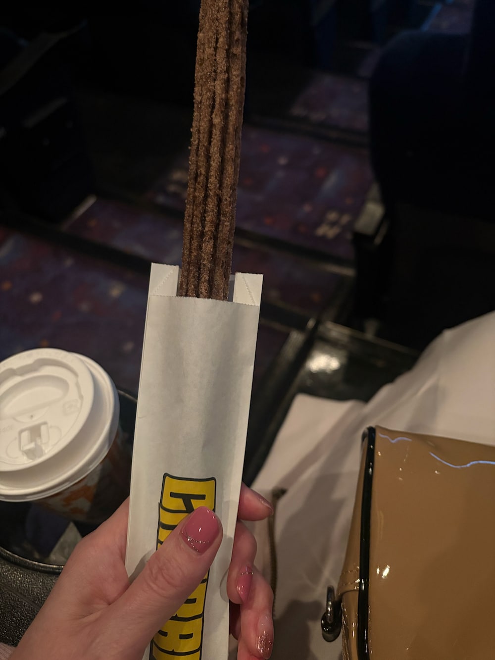 ベージュ系のスカート、ベージュ系のショルダーバッグ、ホワイト系のスニーカーを着用したレディースの冬コーディネートの2枚目の写真