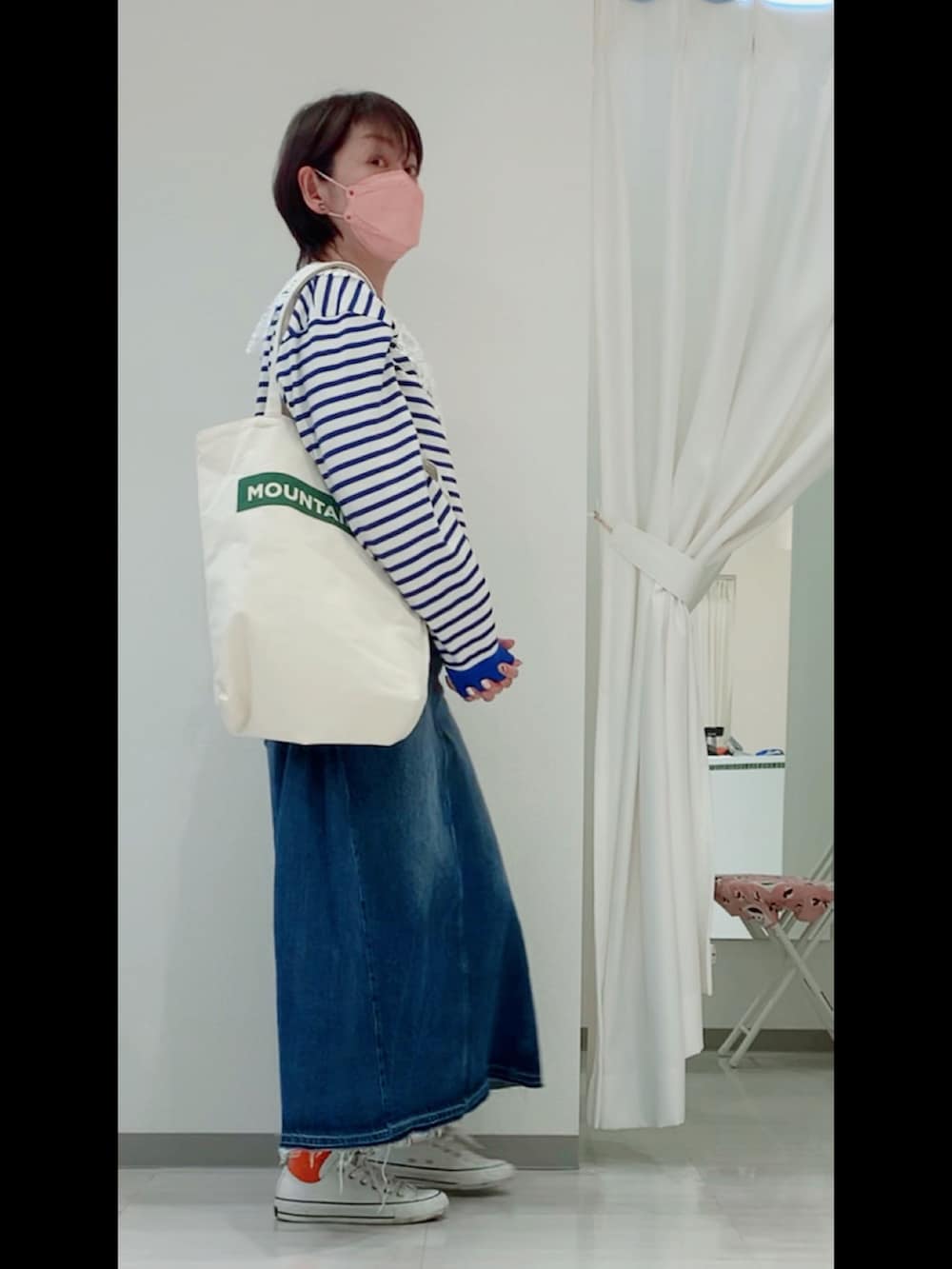 ブルー系のTシャツ/カットソー、ブルー系のデニムスカート、ホワイト系のスニーカーを着用したレディースの春コーディネートの2枚目の写真