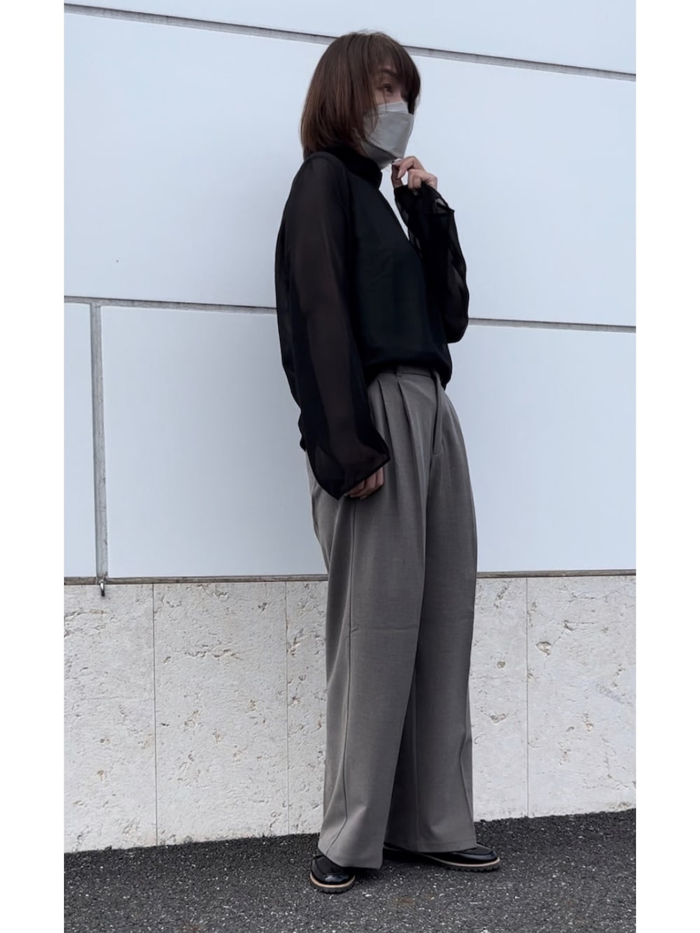 ブラウン系のバッグ、ブラウン系のスラックス、ブラック系のシャツ/ブラウスを着用したレディースの秋コーディネートの2枚目の写真