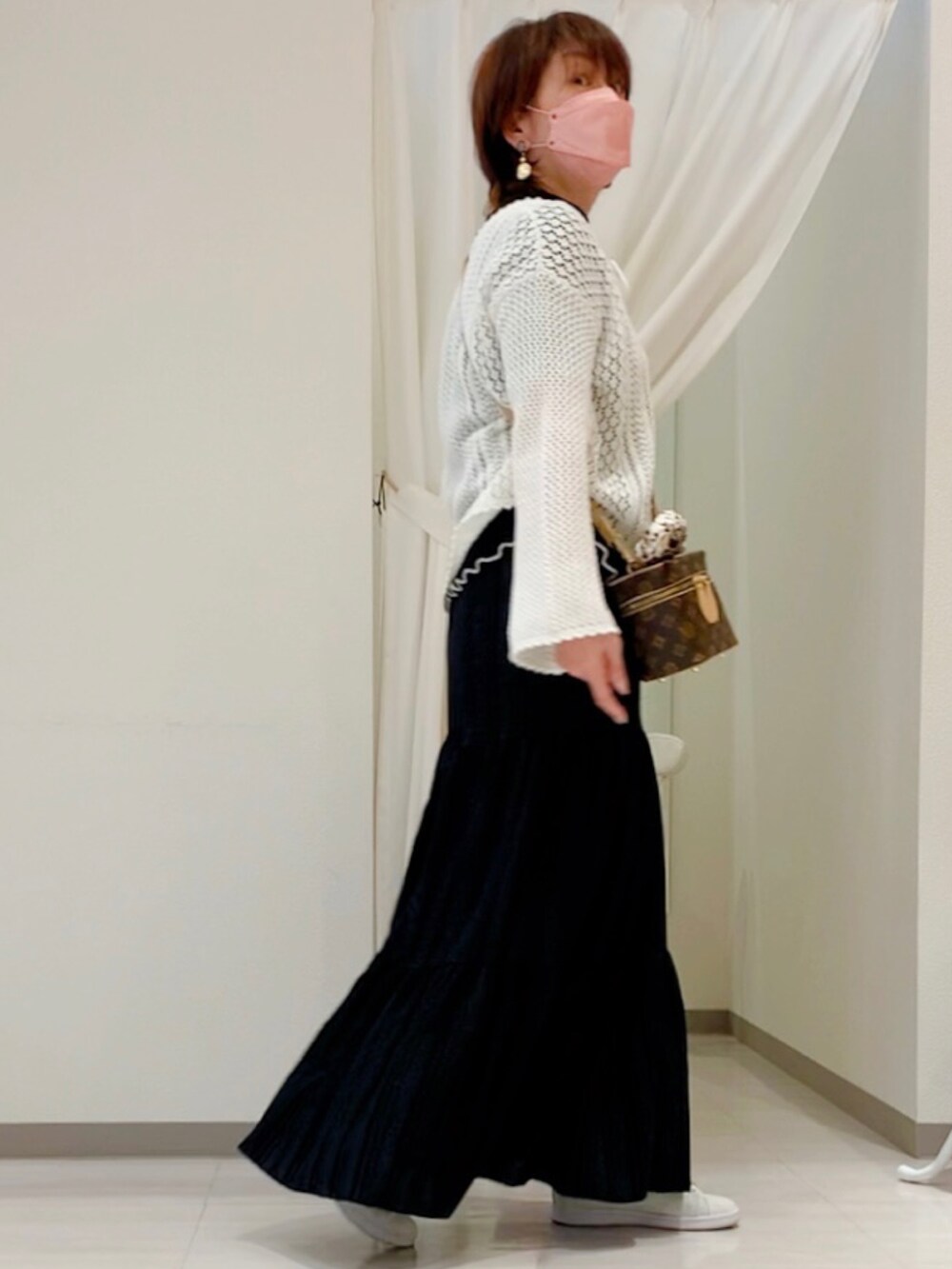 ホワイト系のニット/セーター、ブラウン系のボディバッグ/ウエストポーチ、ブラック系のスカートを着用したレディースの春コーディネートの4枚目の写真