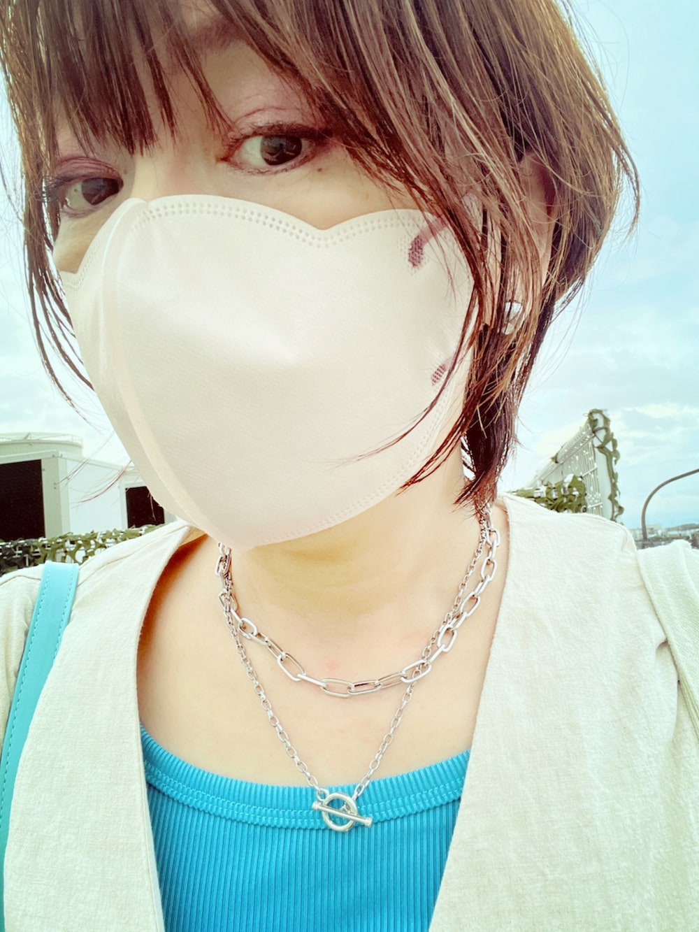 ブルー系のショルダーバッグ、ブルー系のタンクトップ、ホワイト系のスカートを着用したレディースの夏コーディネートの2枚目の写真