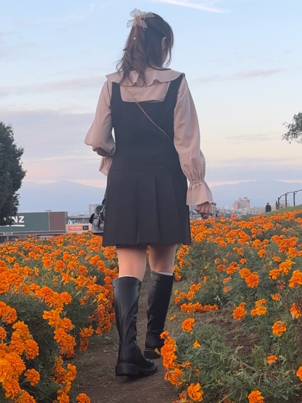 ブラック系のブーツ、ピンク系のシャツ/ブラウス、ブラック系のワンピースを着用したレディースの秋コーディネートの2枚目の写真