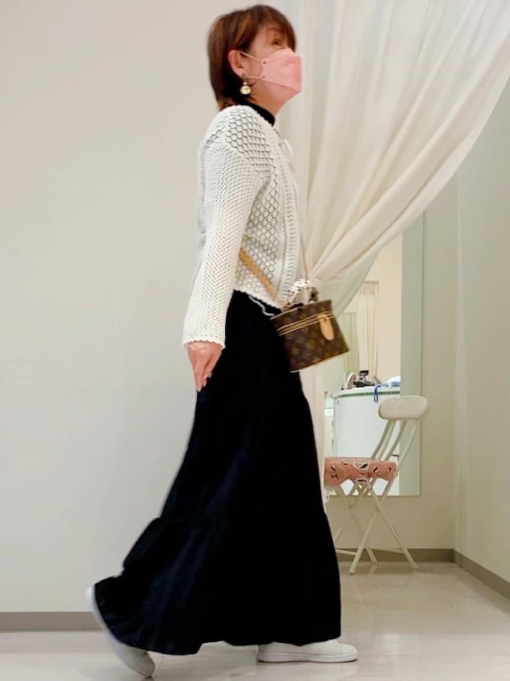 ホワイト系のニット/セーター、ブラウン系のボディバッグ/ウエストポーチ、ブラック系のスカートを着用したレディースの春コーディネートの3枚目の写真