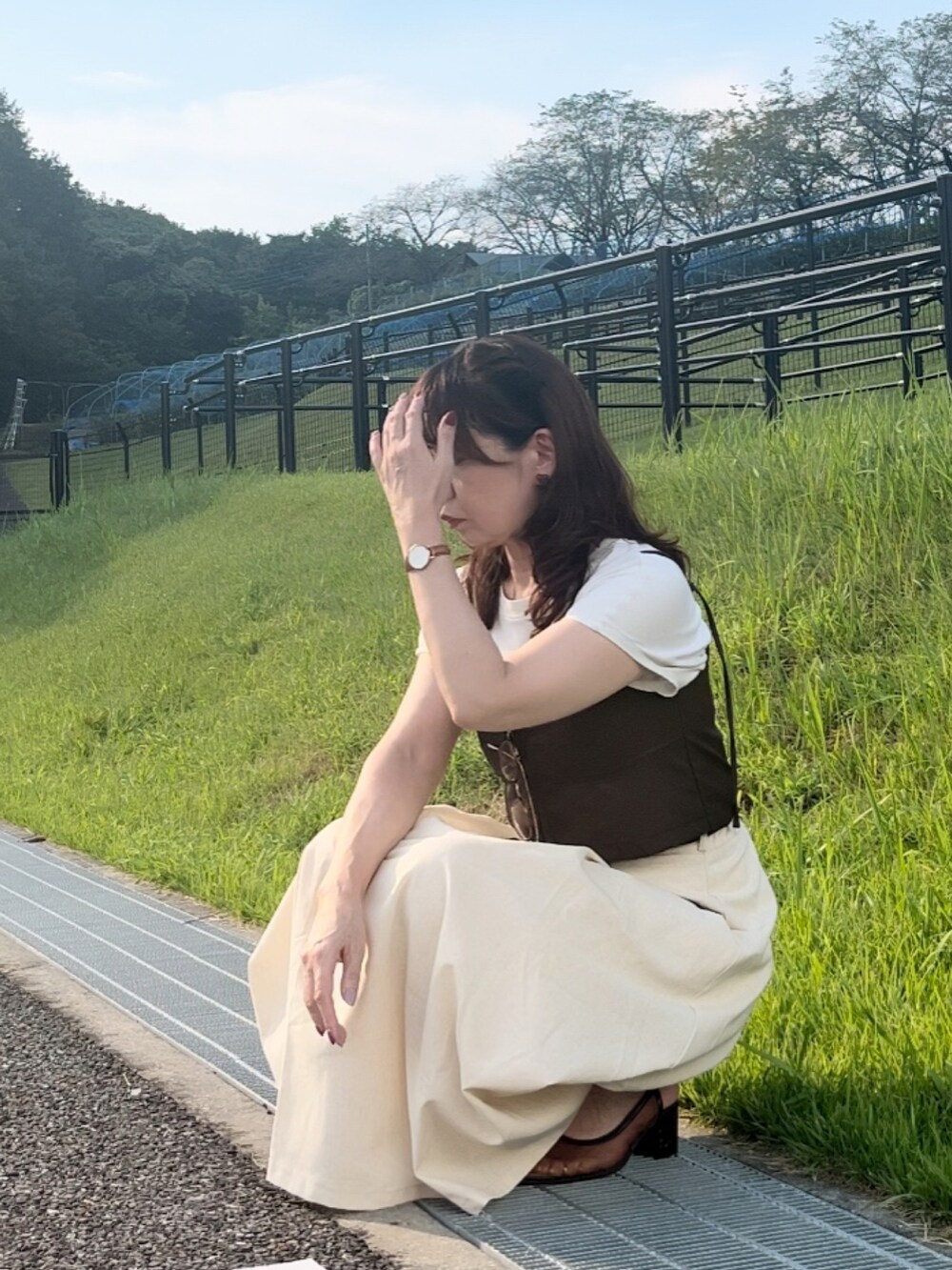 その他のキャミソール、ホワイト系のスカート、ブラウン系のサンダルを着用したレディースの秋コーディネートの2枚目の写真