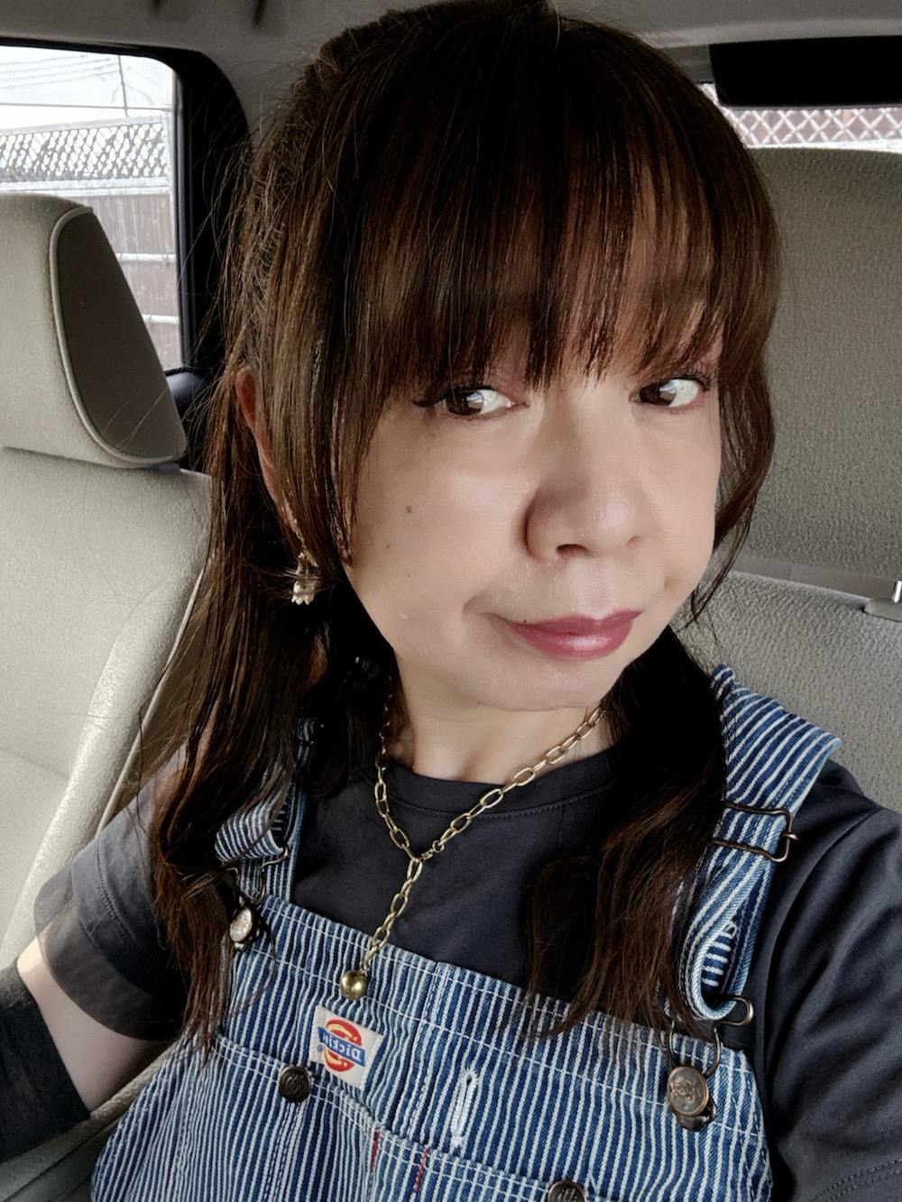 グレー系のTシャツ/カットソー、ブルー系のサロペット/オーバーオール、ブラック系のサンダルを着用したレディースの夏コーディネートの4枚目の写真